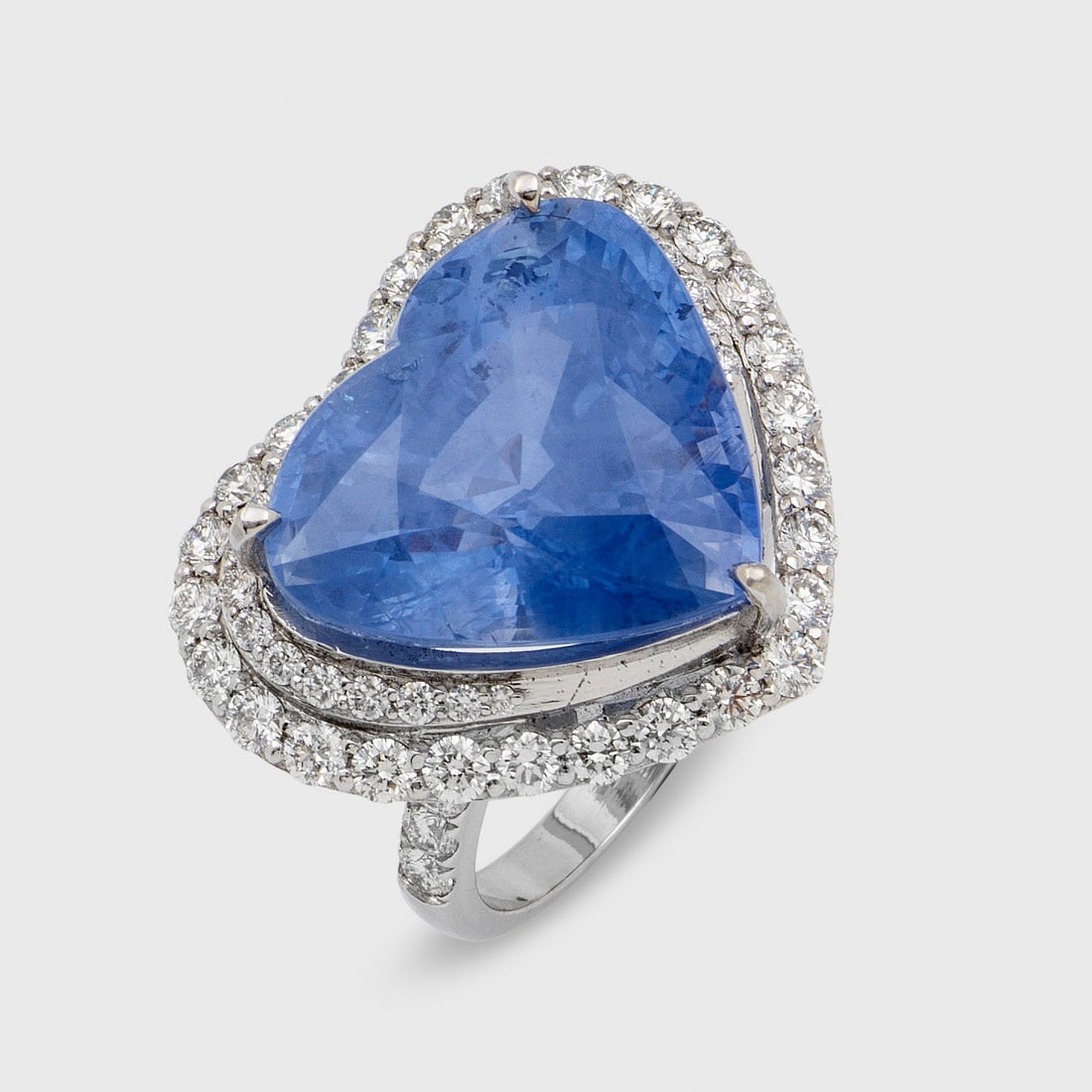 Glamouröser Saphir-Herzring: Platin, gest. 900. Zentral besetzt mit einem kornblumenblauen Saphir von ca. 24,31 ct. im Herzschliff, entouriert von Brillanten von zus. ca. 1,72 ct.; Gew. ca. 16,05 g. Beiliegend Expertise. Ring set