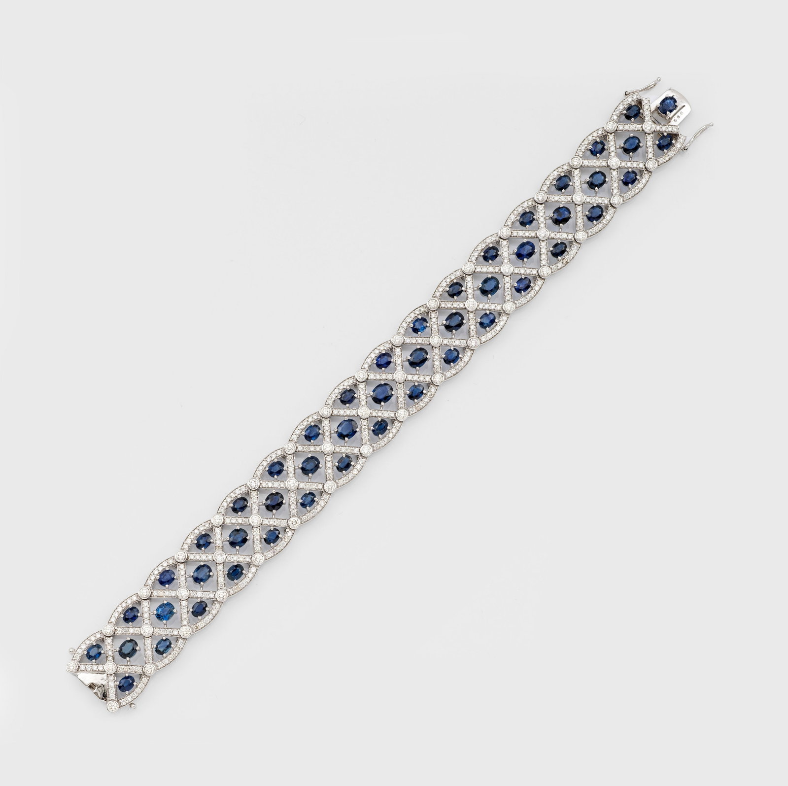 Saphir-Brillant-Armband im traditionellen Juwelenstil: Weißgold, gest. 585. Schauseitig besetzt mit tiefblauen Saphiren von zus. ca. 13,62 ct. im Ovalschliff, akzentuiert durch Brillanten von zus. ca. 5,21 ct.; Gew. ca. 22,90 g. Bracelet set with