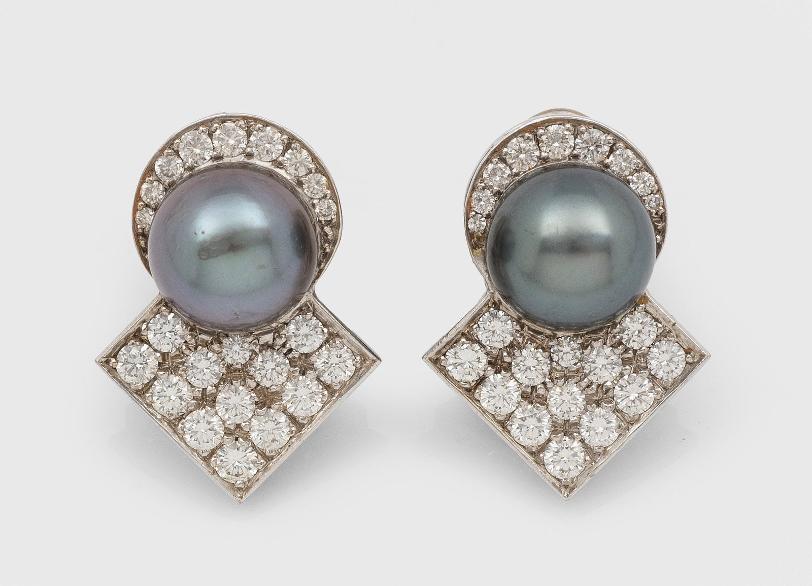 Paar repräsentative Tahiti-Perl-Brillant-Ohrclips: Weißgold, 18 ct.; Jeweils besetzt mit makelloser Tahiti-Zuchtperle von ca. 13 mm in sehr farbintensivem, violett-grün changierendem Lüster, ausgefasst mit Brillanten von zus. ca. 2,00 ct.;