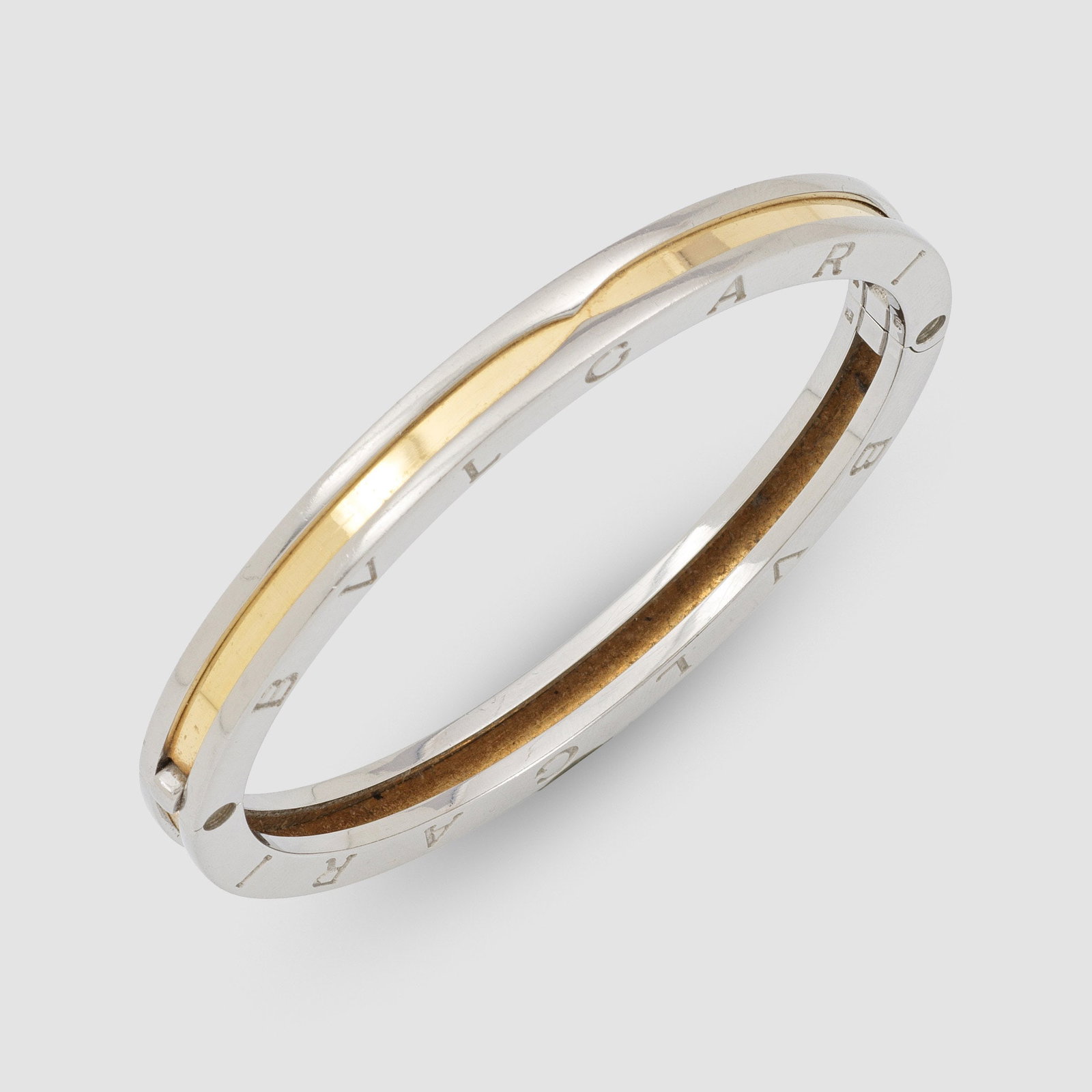 Armreif von BVLGARI-"B Zero 1": Stahl und Gelbgold, gest. 750. Profilierter Scharnierreif, beidseitig Schriftzug "BLVLGARI BVLGARI". Herstellerzeichen. Gew. 30,11 g. Bracelet by BVLGARI in steel and 18 k gold. Maker's mark.