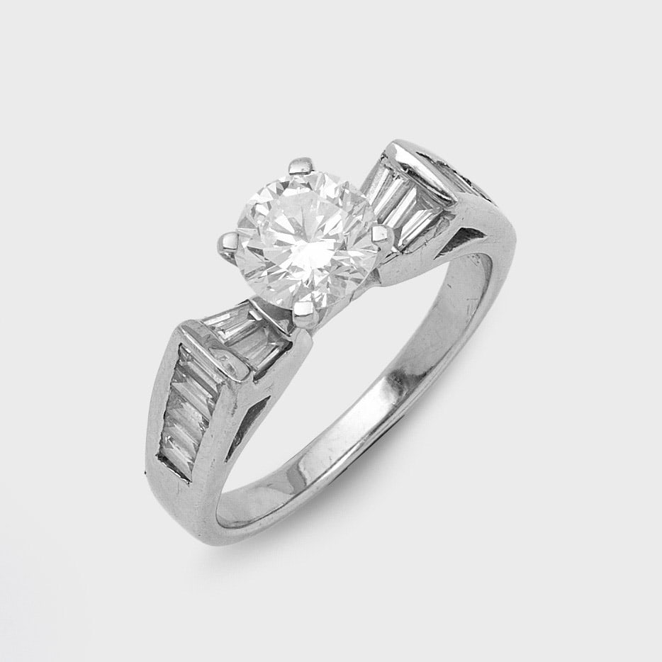 Eleganter Brillantsolitär-Ring: Weißgold, gest. 750. Zentral besetzt mit einem Brillant von ca. 1,00 ct. (I-J/vs), flankiert von Diamant-Baguetten von zus. 0,60 ct.; Gew. ca. 4,44 g. Ring set with a brilliant solitaire approx. 1,00