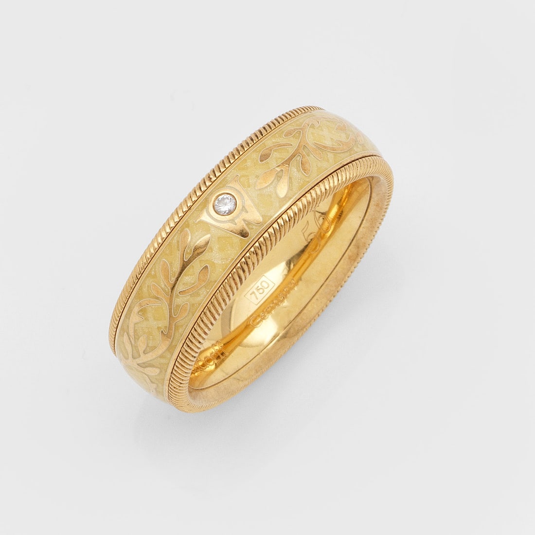 Klassischer Bandring-'Trüffel"von Wellendorf: Gelbgold, teilw. elfenbeinfarben emailliert, gest. 750. Drehbare Bandringschiene mit umlaufend fein geriffeltem Band und Logo-"W" mit kleinem Brillanten. Herstellerzeichen. Gew. ca. 13,29 g. Original 