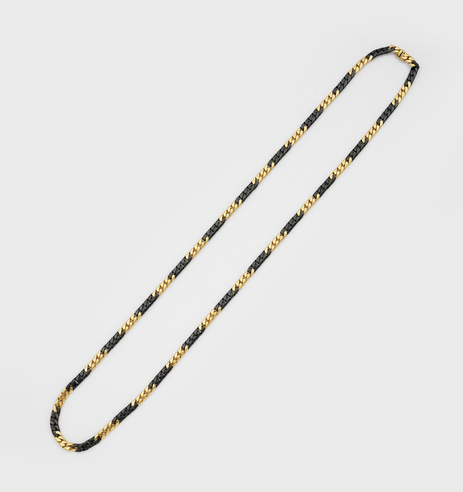 Sautoire von Faraone Gioielli, Milano, 1981: Gelbgold und Stahl, gest. 750. Lange Flachpanzerkette, im dekorativen Wechsel massiv gefertigte Glieder aus Stahl und Gold. Gew. ca. 56,99 g. Sehr schöne Goldschmiedeausführung. Beiliegend Original-