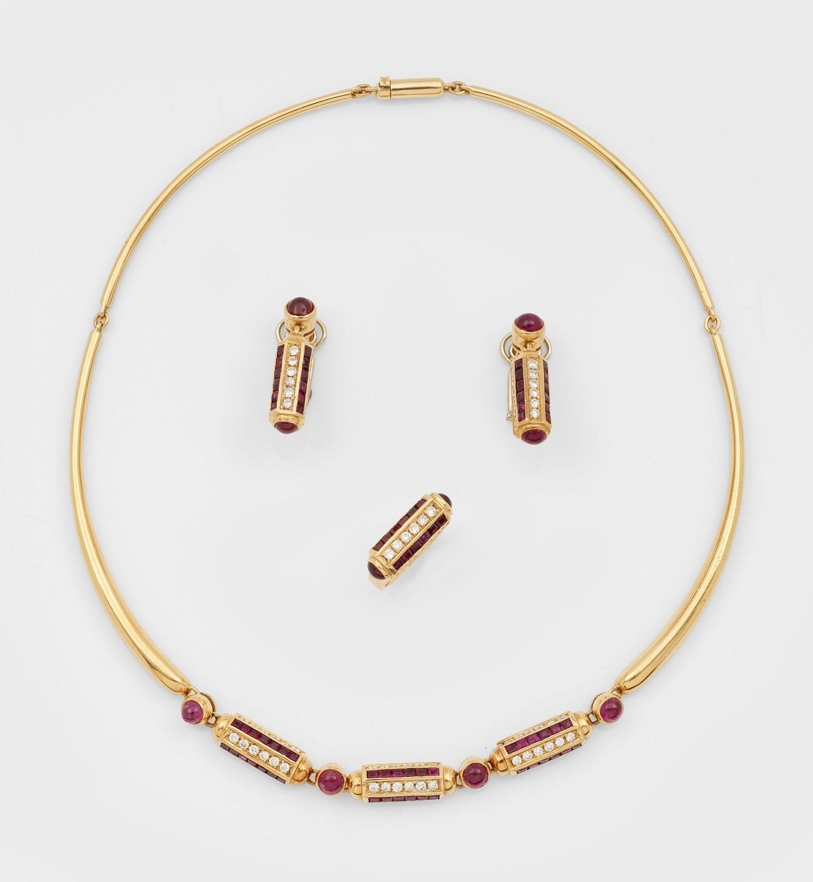 Diamant-Rubin-Parure von Sergio Nardi, Venedig von 1980: Gelbgold, gest. 750. Collier, korrespondierendes Paar Ohrclips und Ring. Collier besetzt mit Brillanten von zus. ca. 1,35 ct. (G-H/vvs-vs) und Rubinen von zus. ca. 3,70 ct., in Carrée- und Cabochonsc