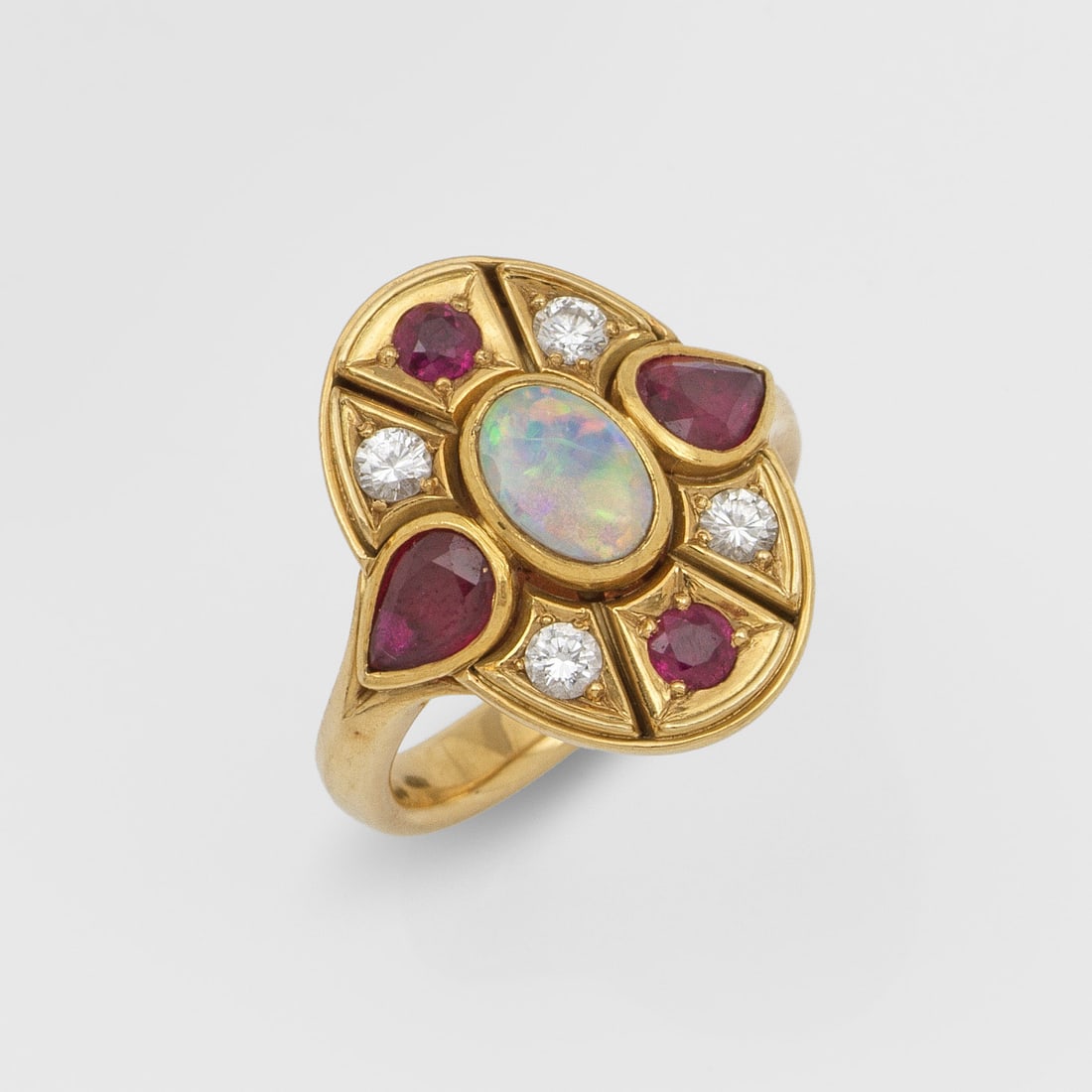 Dekorativer Opal-Rubinring: Gelbgold, gest. 750. Medaillonförmiger Ringkopf, zentral besetzt mit einem Opalcabochon von besonders schönem Farbspiel, entouriert von taubenblutroten Rubinen von zus. ca. 0,80 ct. und Brillanten v