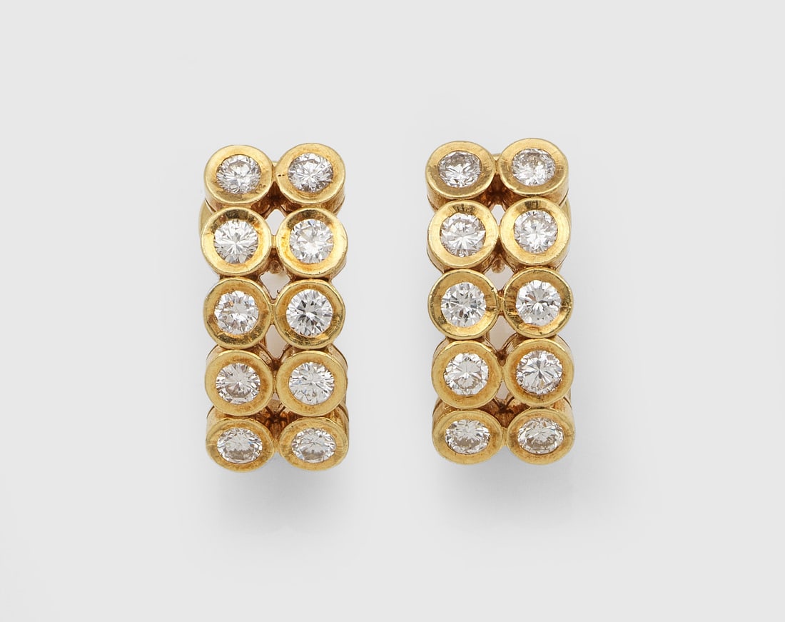 Paar Tennis-Brillant-Ohrclips: Gelbgold, 18 ct.; Linear besetzt mit Brillanten von zus. ca. 1,80 ct. (H-J/si). Ges.-Gew. ca. 11,96 g. Pair of earclips set with diamonds approx. 1,80 ct. (H-J/si), in 18 k gold.