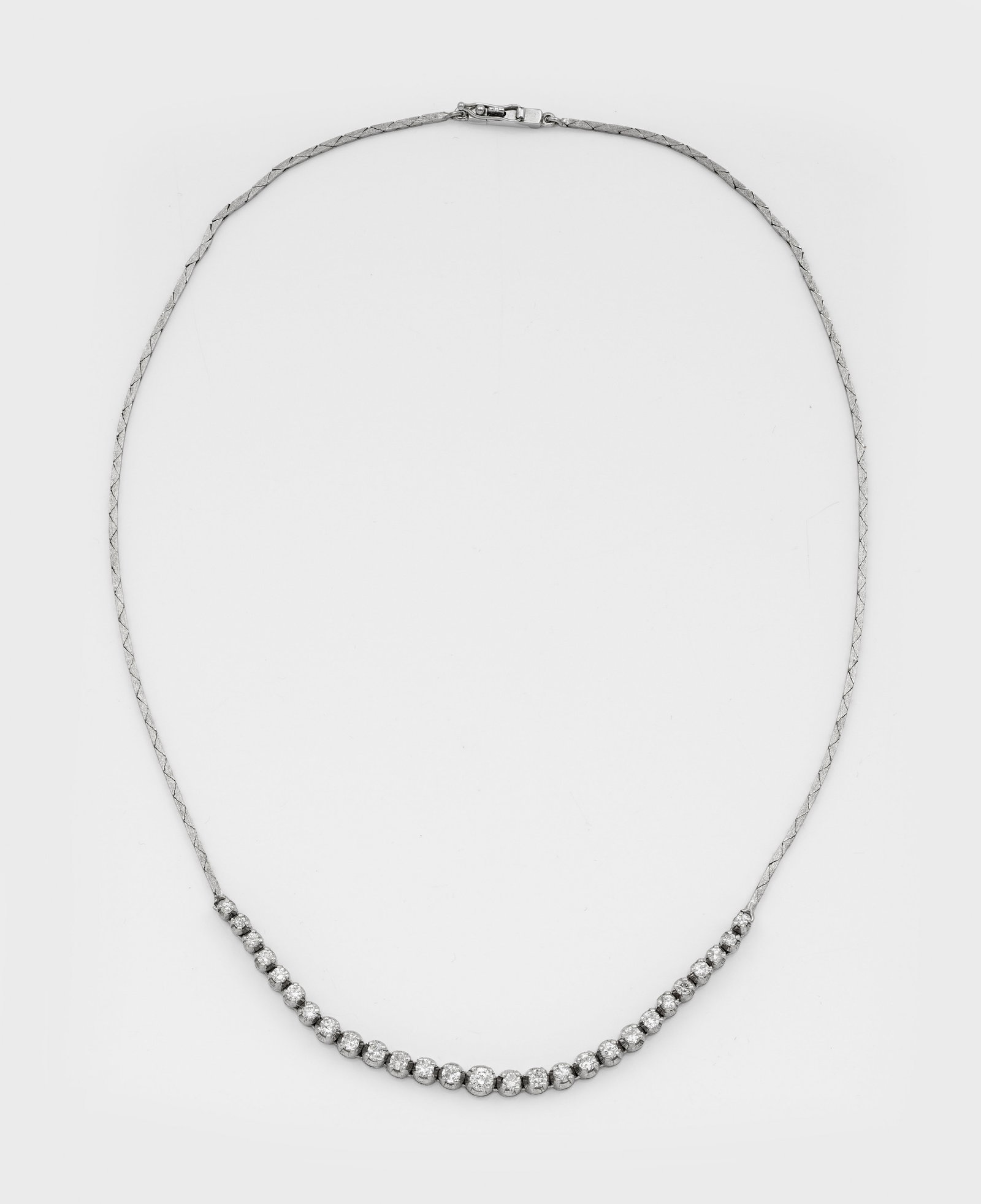 Brillant-Rivière-Collier: Weißgold, gest. 750. An feiner Milanese-Kette, mittig linear besetzt mit Brillanten von zus. ca. 1,00 ct.; Gew. ca. 14,65 g. Necklace set with diamonds approx. 1,00 ct., in 18 k white gold.