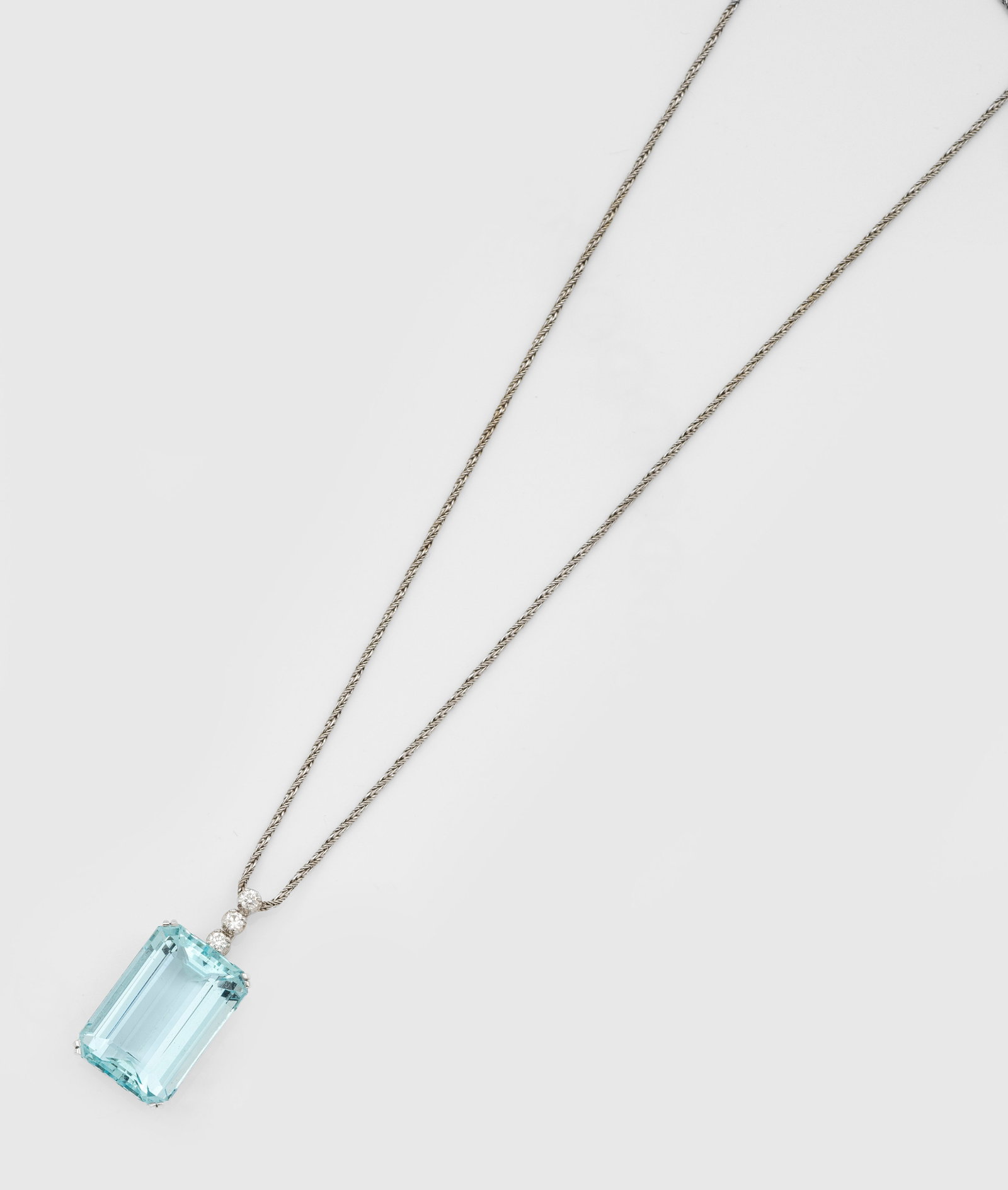 Aquamarin-Brillant-Anhänger: Weißgold, gest. 750. Eisblauer Aquamarin von ca. 24 x 16 x 11 mm, bekrönt von 3 Brillanten von zus. ca. 0,30 ct. (H/vs), an feiner Kordelkette. Ges.-Gew. ca. 15,32 g. Pendant set with an aquamarine 