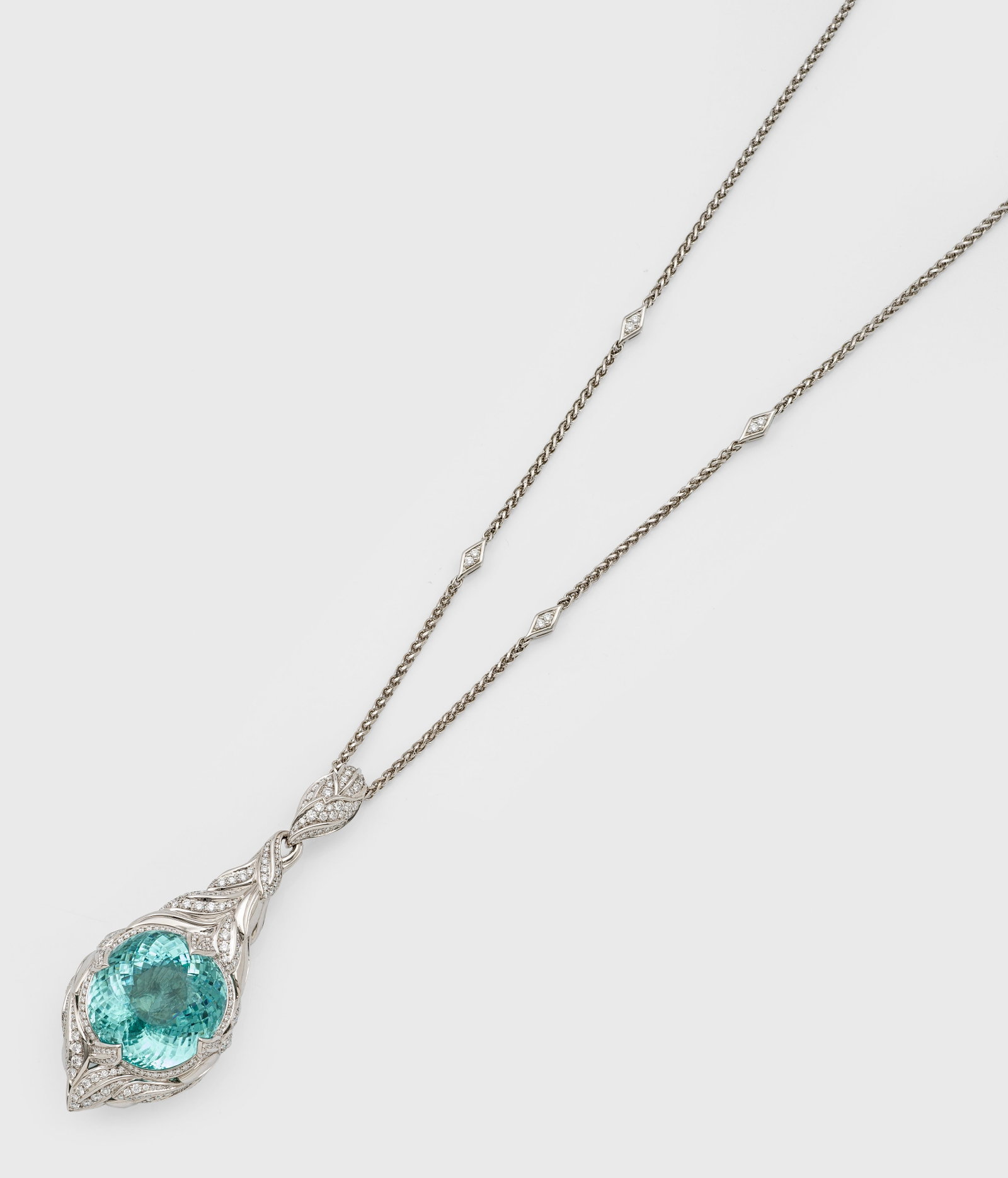 Glamouröser Anhänger mit Paraiba Neon Blue-Turmalin: und Diamant-Sautoire aus dem Atelier Kat Florence, Bangkok Weißgold, gest. 18 ct.; Tropfenförmiger Anhänger aus plastisch gestaltetem Blattwerk in Ajour, zentral besetzt mit einem seltenen, leuchte