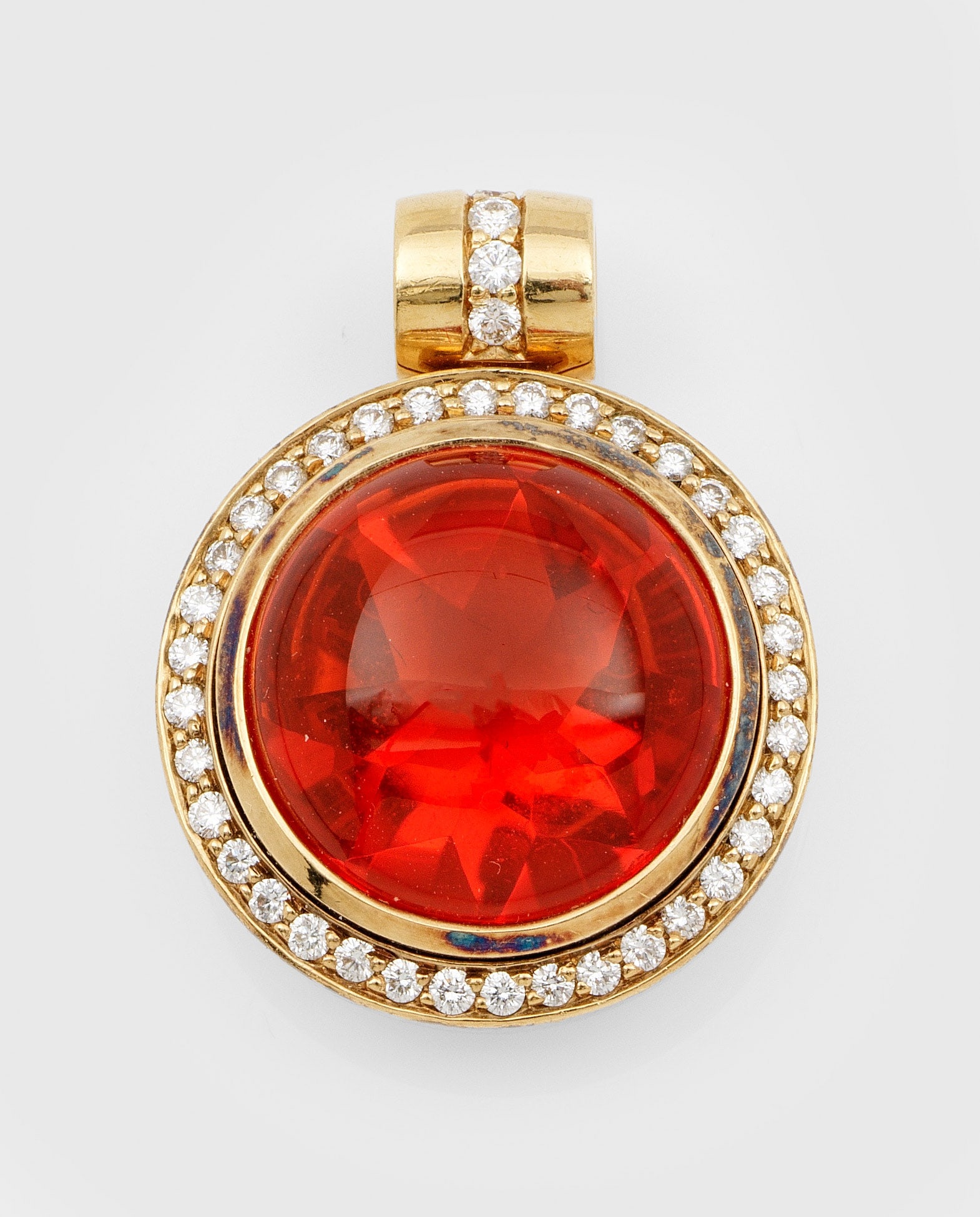 Mexikanischer Feueropal-Anhänger mit Brillanten: Gelbgold, gest. 750. Zentral besetzt mit einem tief orangefarbenen Feueropal im Cabochonschliff, entouriert mit Brillanten von zus. ca. 0,50 ct.; Gew. ca. 14,55 g. Pendant set with a dark orange opal 