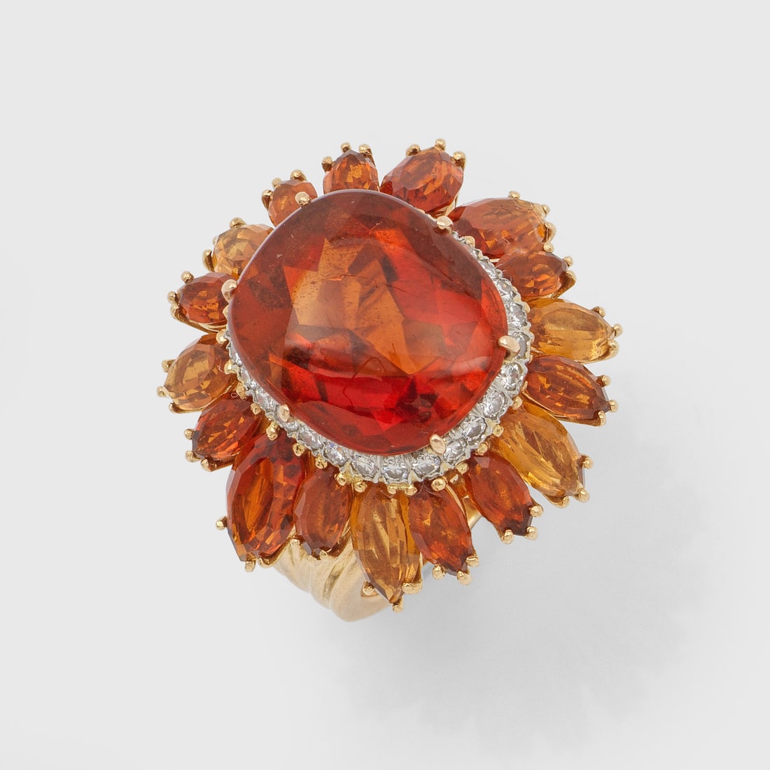 Extravaganter Citrinring: Gelbgold, gest. 750. Ringkopf dekorativ gestaltet als stilisierte Sonnenblume, besetzt mit orangegelben sowie orangebraunen Citrinen, akzentuiert durch kleine Diamanten. Gew. ca. 18,68 g. Ring set wit