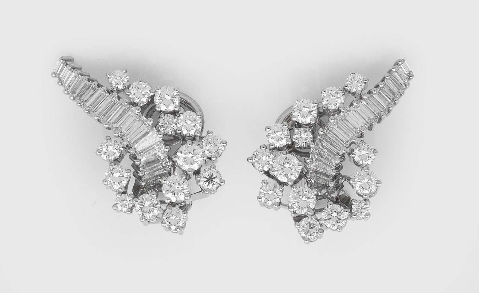 Paar mondäne Cocktail-Diamant-Ohrclips: Weißgold, gest. 750. Schauseitig besetzt mit Brillanten und Diamant-Baguetten von zus. ca. 1,70 ct. (F-G/H/vvs-vs). Ges.-Gew. ca. 9,48 g. Pair of earclips set with diamonds approx. 1,70 ct. (F-G/H/vv