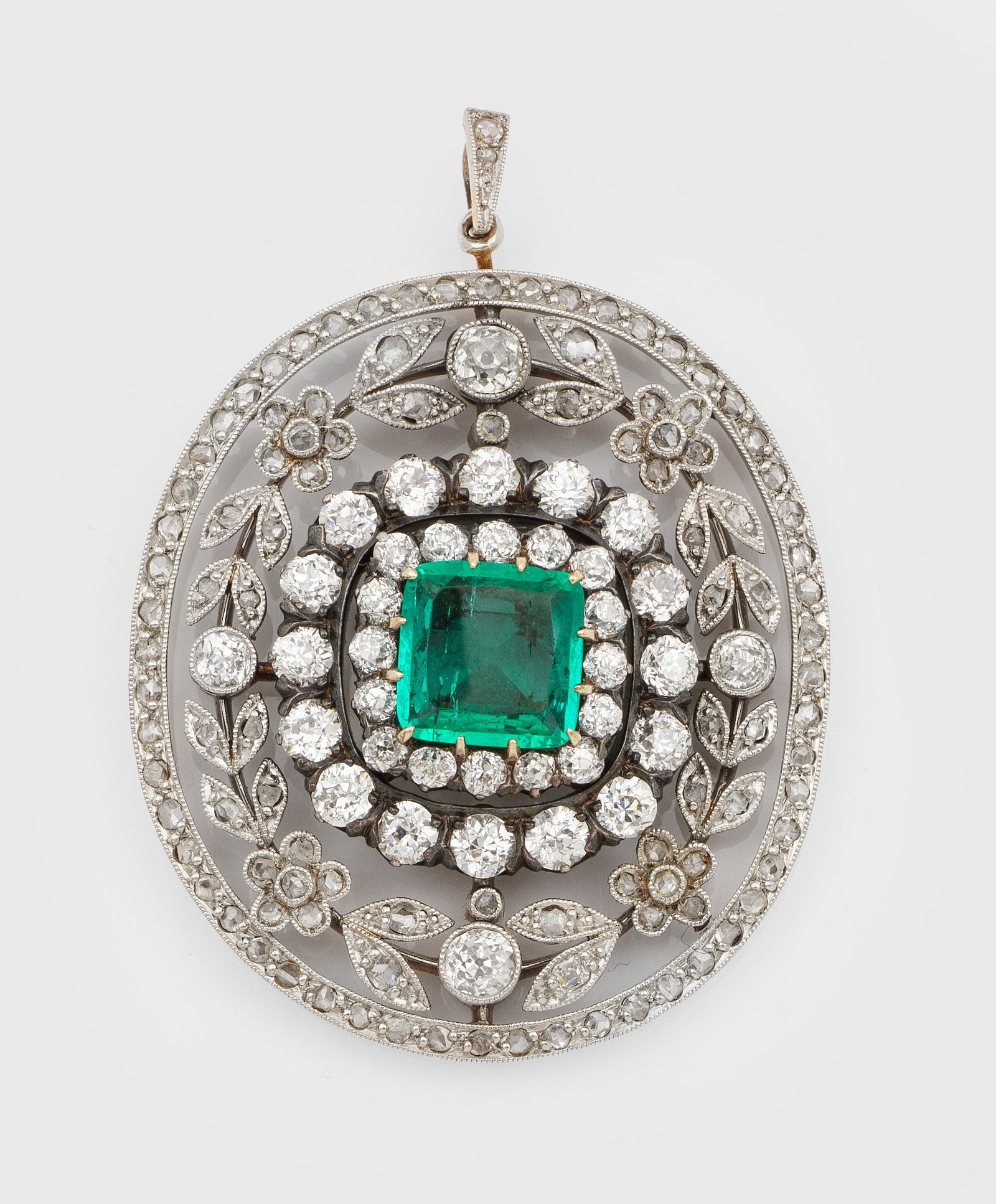 Jugendstil Diamant-Anhänger mit kolumbianischem Smaragd: Gelbgold, 14 ct.; teilw. platiniert. Floral gestaltete Medaillonform in Ajour, zentral besetzt mit einem leuchtendgrünen Smaragd von ca. 3,00 ct., entouriert von Altschliffdiamanten und Diamantrosen 