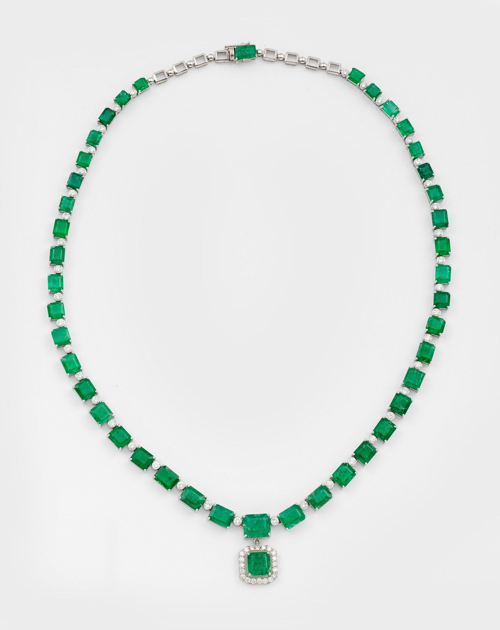 Repräsentatives Smaragd-Brillant-Collier: Weißgold, gest. 585 ct.; Schauseitig im leichten Verlauf besetzt mit Smaragden und korrespondierendem Anhänger von zus. ca. 37,58 ct., unterteilt durch Brillanten von zus. ca. 2,24 ct.; Ges. Gew. ca
