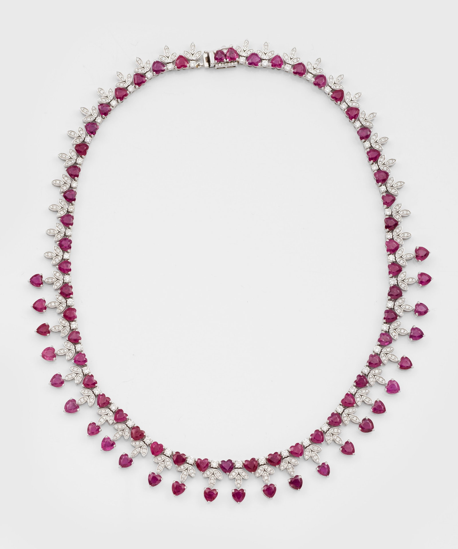 Elegantes Rubin-Brillant-Collier: Weißgold, gest. 585. Schauseitig besetzt mit fromboisefarbenen Rubinen von zus. ca. 39 ct. im Herzschliff, akzentuiert durch Brillanten von zus. ca. 6,0 ct.; Gew. ca. 42,26 g. Necklace set with ruby 