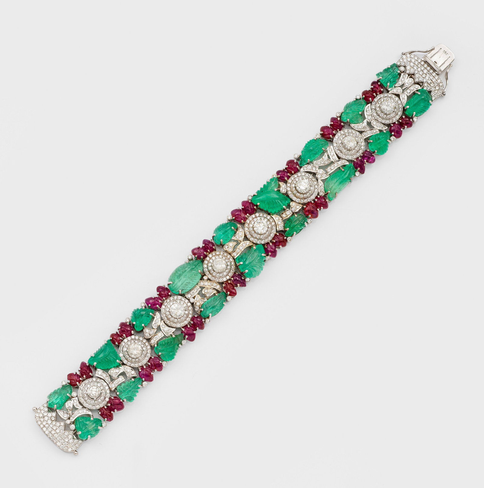 Glamouröses Armband im "Tutti Frutti" Stil von Cartier: Weißgold, gest. 750. Ausgefasst mit taubenblutroten Rubinen von ca. 13 ct. und Smaragden von zus. ca. 32,53 ct. floral graviert, akzentuiert durch Diamanten von zus. ca. 6,29 ct.; Gew. ca. 51,50 g. V