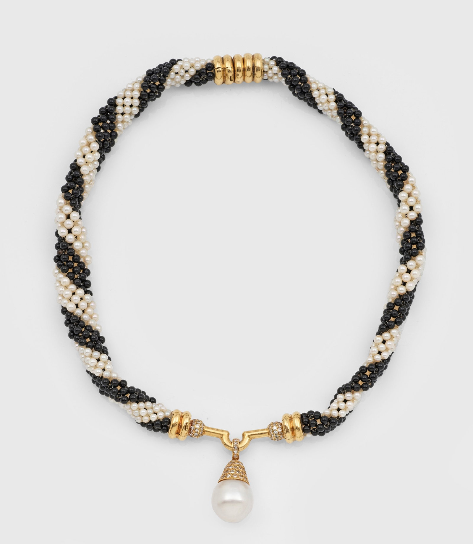 Mondänes Perl-Collier der 1980er Jahre: Gelbgold, gest. 750. Collierkette aus gehäkelten, weißen Zuchtperlen und schwarzen Onyxperlen, mittig eingesetzte weiße Südsee-Zuchtperle von ca. 15 mm in sehr farbintensivem, rosé-grün changier