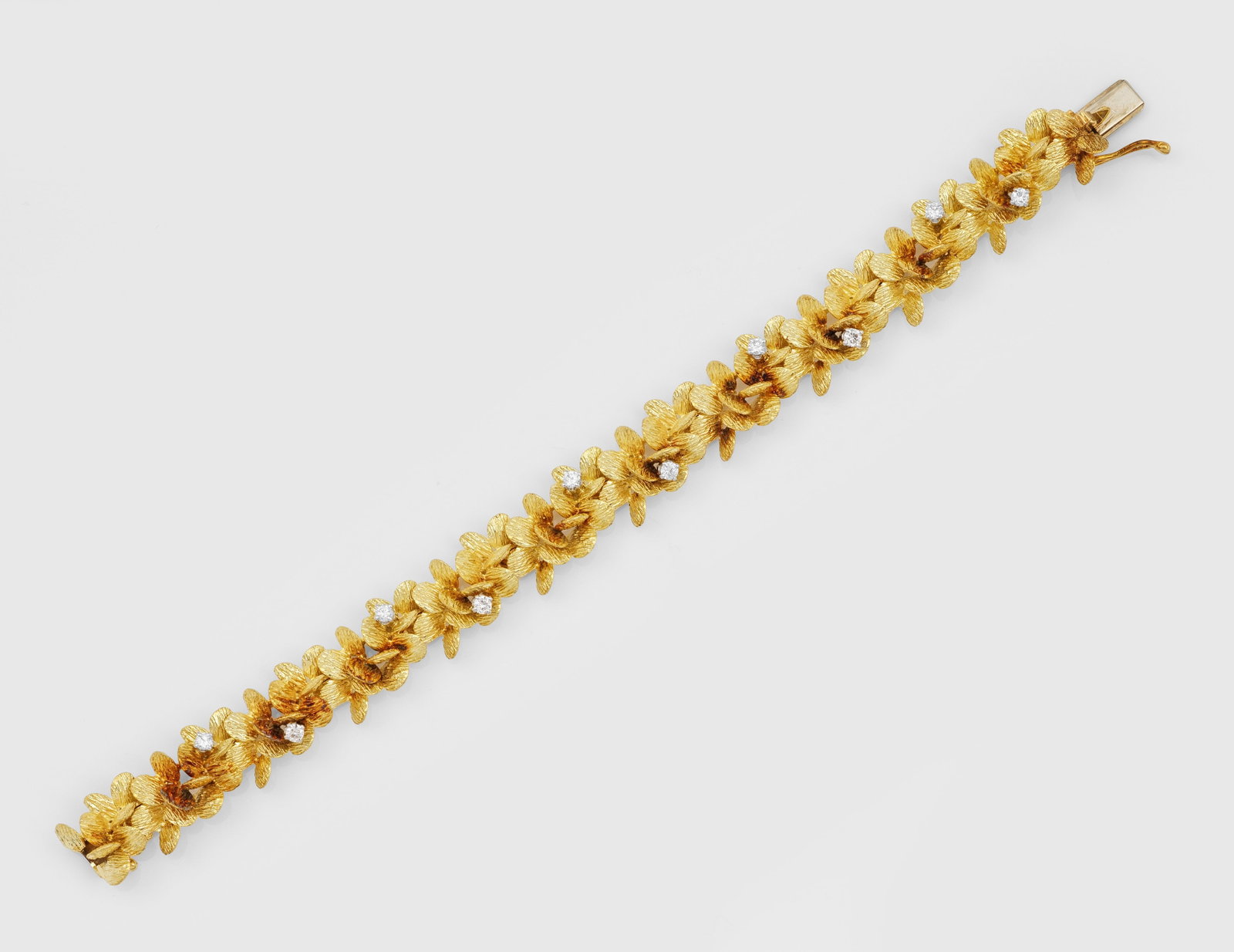 Florales Brillant-Armband von LOTOS: Gelbgold, gest. 750. Plastisch gestaltet aus fein geriffelten Blütenblättern, akzentuiert durch Brillanten von zus. ca. 0,50 ct.; Gew. ca. 61,48 g. Bracelet by LOTOS set with diamonds approx. 0,50