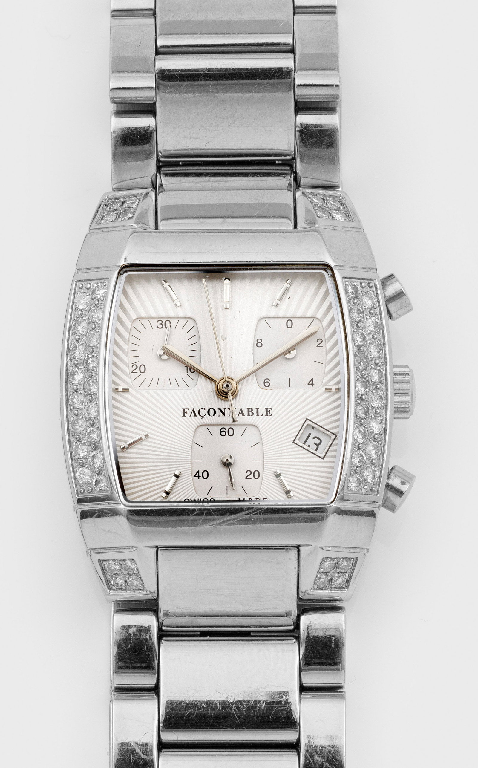 Armbanduhr von Façonnable: Edelstahl. Tonneauförmiges Uhrengehäuse, Lünette besetzt mit 50 Diamanten von ca. 0,83 ct., satiniertes, profiliertes Zifferblatt, Stabindexe und Lanzenzeiger, Chronograph aus der Mitte mit 1/10 Se