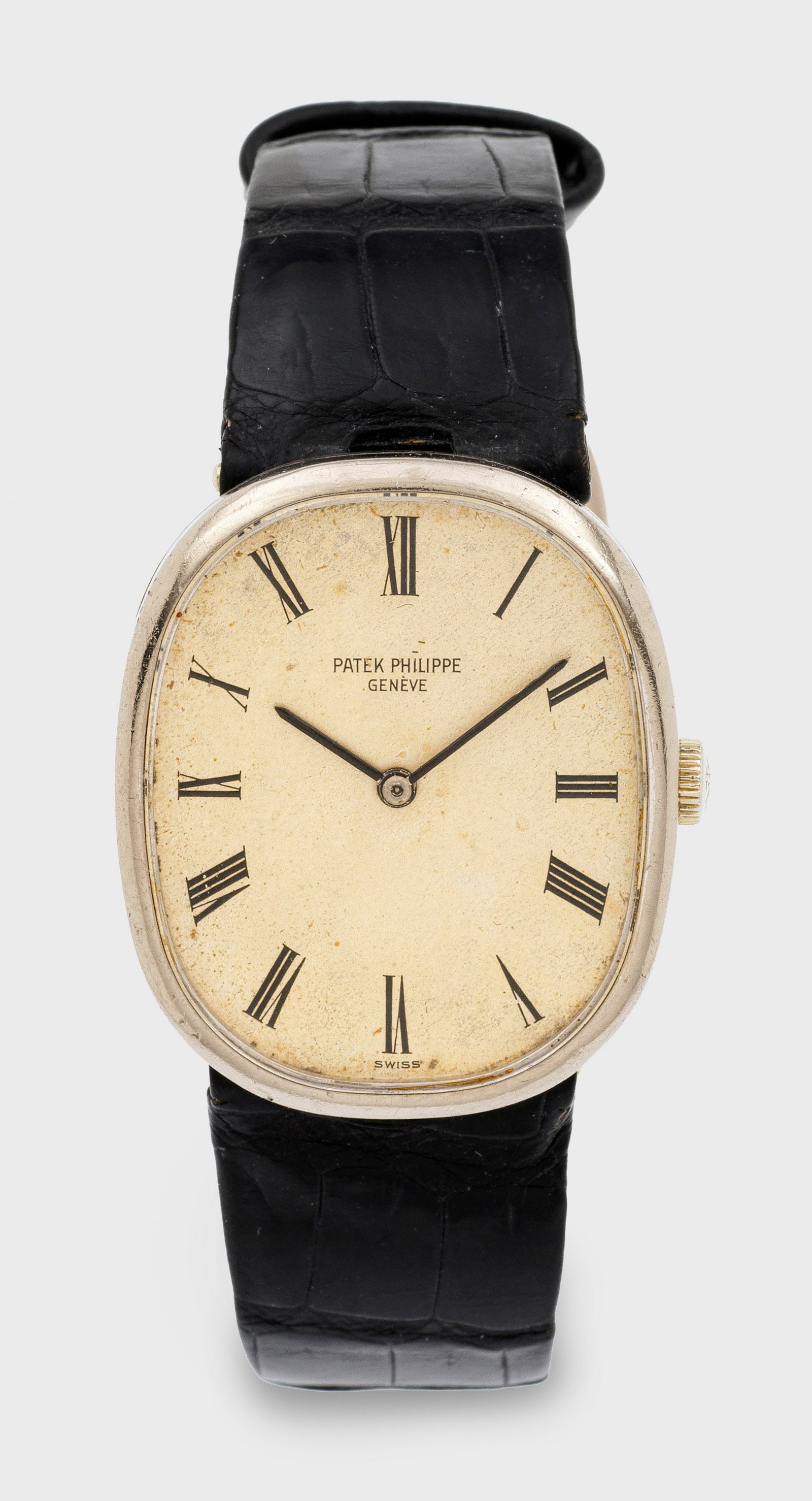 Herrenarmbanduhr von Patek Philippe-"Ellipse" von 1973: Weißgold, gest. 750. Ellipsenförmiges Uhrengehäuse, silbergekörntes Zifferblatt, schwarze römische Zahlen und Stabzeiger. Schwarzes, geprägtes Lederarmband und Dornenschließe aus Gold.