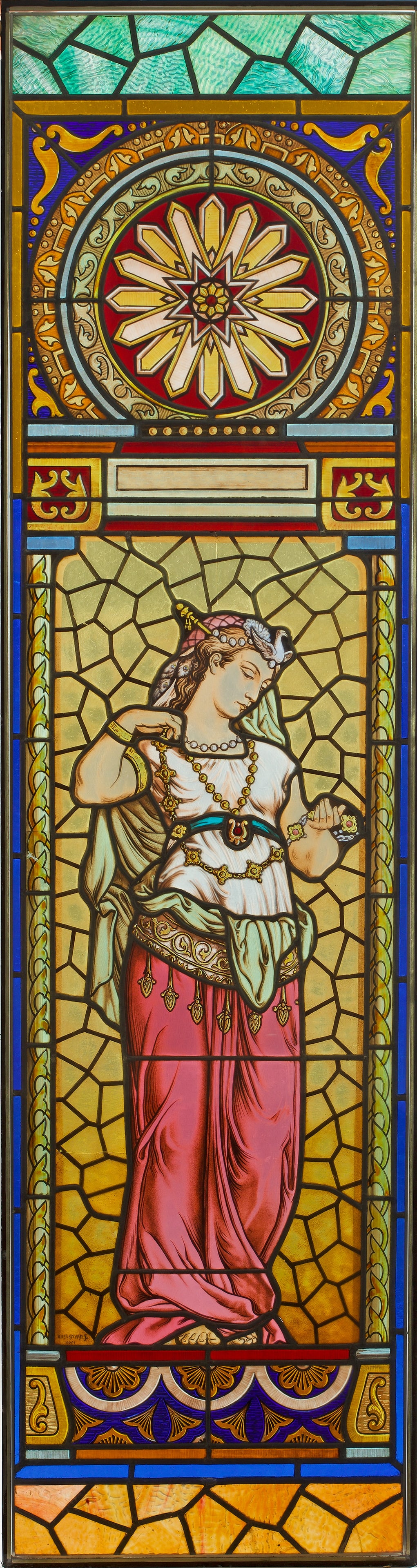 Historismus-Bleiverglasung: Teilw. strukturiertes Glas in unterschiedlichen Farbtönen, farbig akzentuiert. Hochrechteckige Fensterscheibe mit Darstellung einer Muse sowie großem Rosettenmotiv, begrenzt von schmalen Bändern. M
