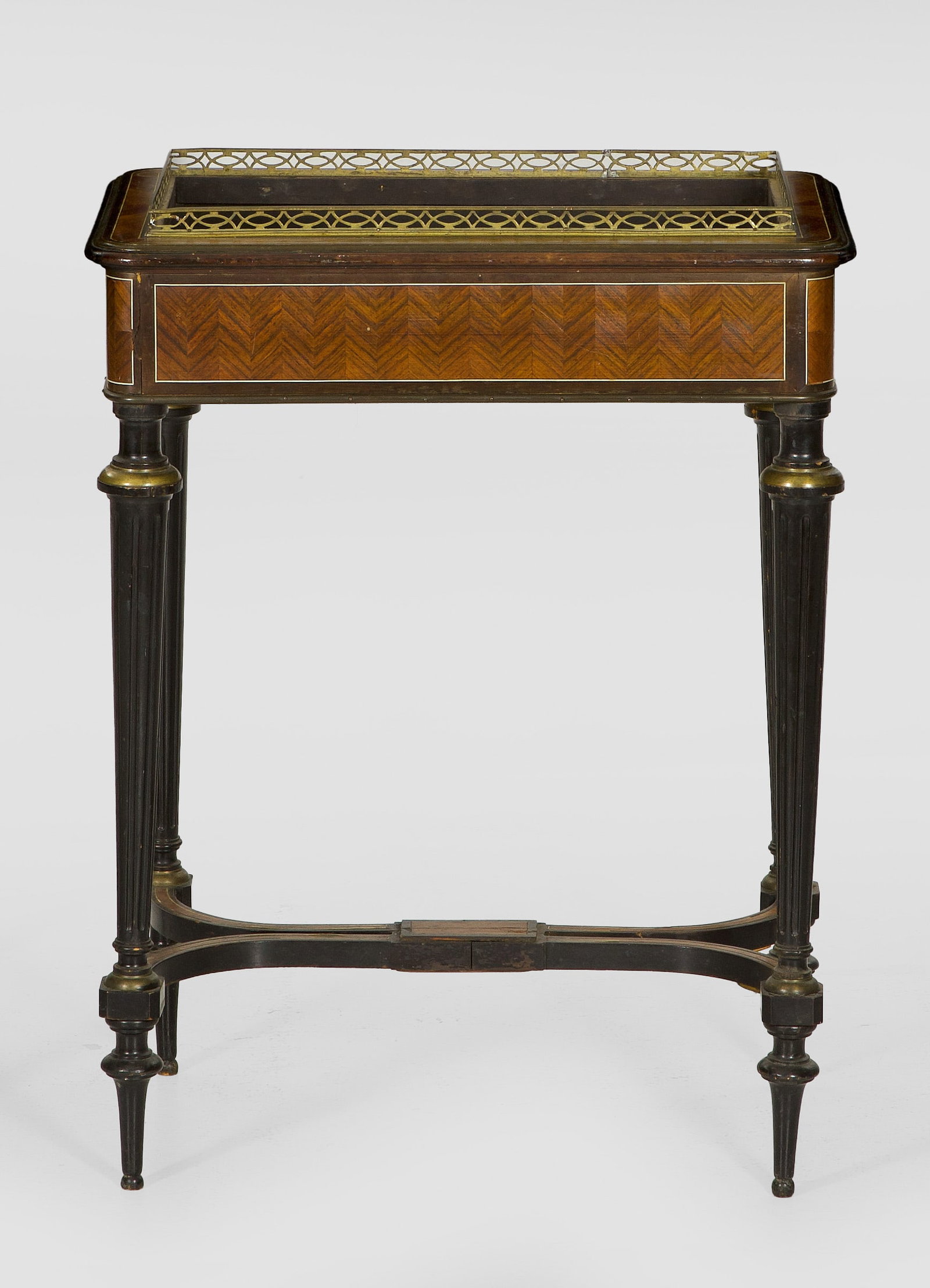 Napoleon III-Jardinière: Nussbaum und Palisander massiv und furniert. Gerader, querrechteckig angelegter Korpus mit gerundeten Ecken auf kannelierten, konischen Balusterbeinen, unterhalb durch gebogte Stege verbunden. Profili