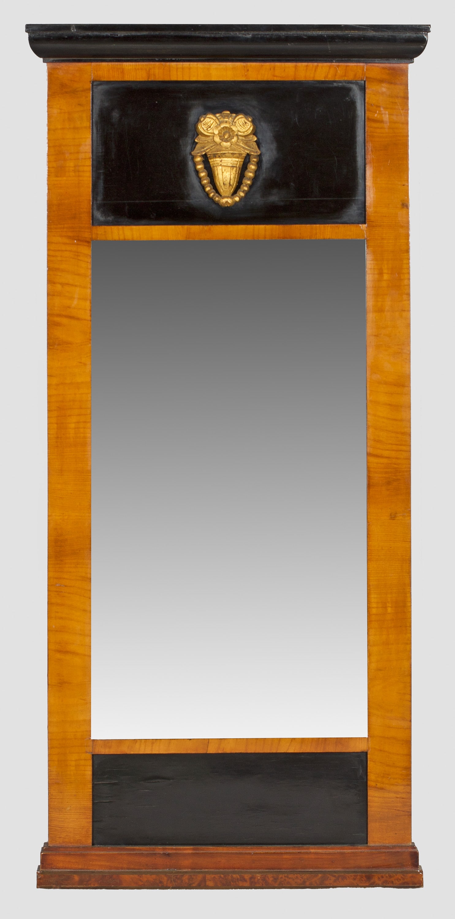Biedermeier-Pfeilerspiegel: Kirschbaum, furniert und teilw. ebonsiert. Gerade, hochrechteckige Spiegelrahmung. Im breiten Giebelfeld appliziertes Blütenmotiv. Schmales Profilgesims. 108 cm x 51,5 cm. A German cherrywood veneere