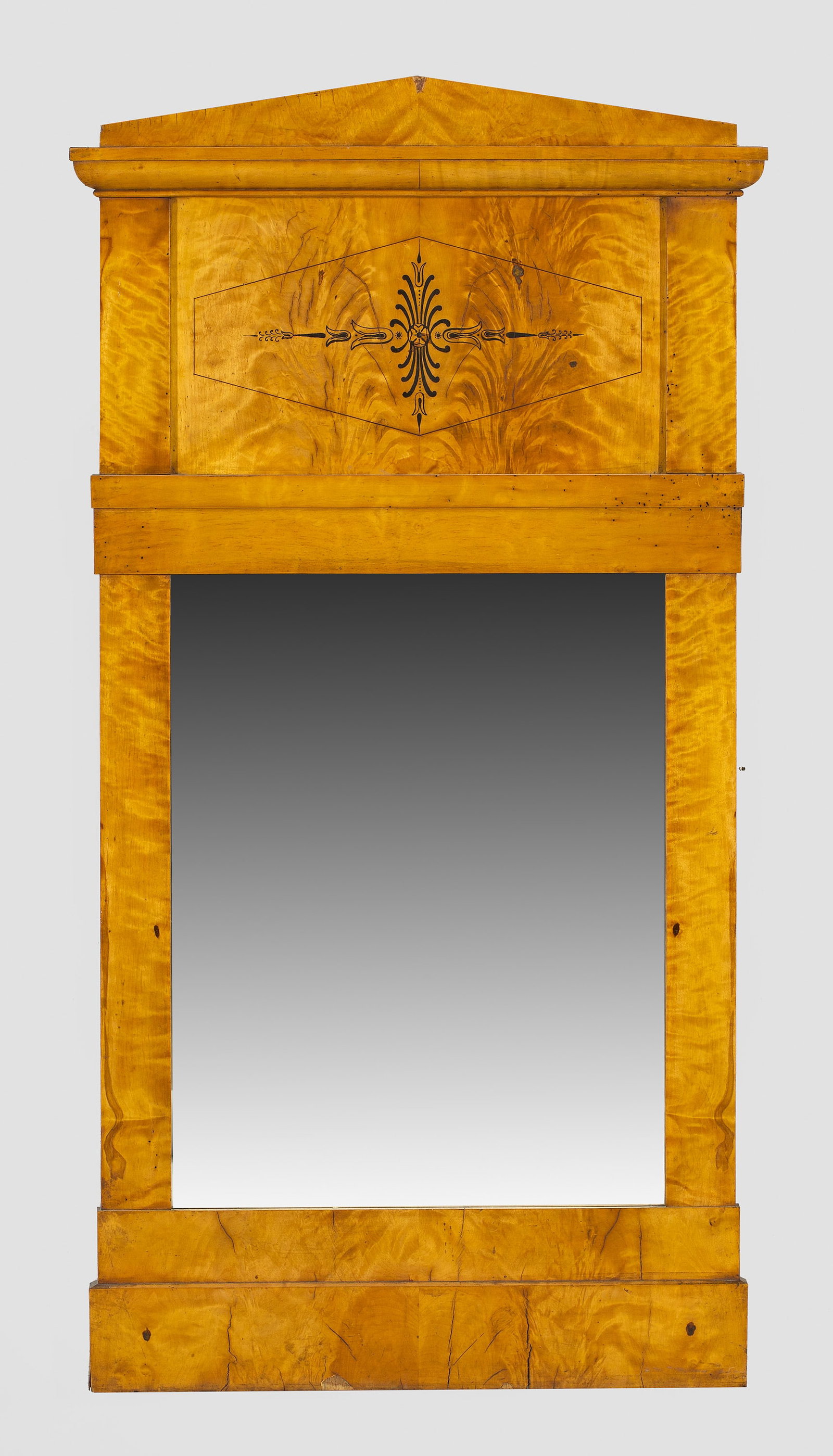Biedermeier-Wandspiegel: Birkenholz, furniert. Gerade, hochrechteckige Spiegelrahmung. Im breiten Giebelfeld Ornamentmotiv in Schwarzlot. Flacher Schinkelgiebel als oberer Abschluss. 126 cm x 67,5 cm. A German birchwood venee