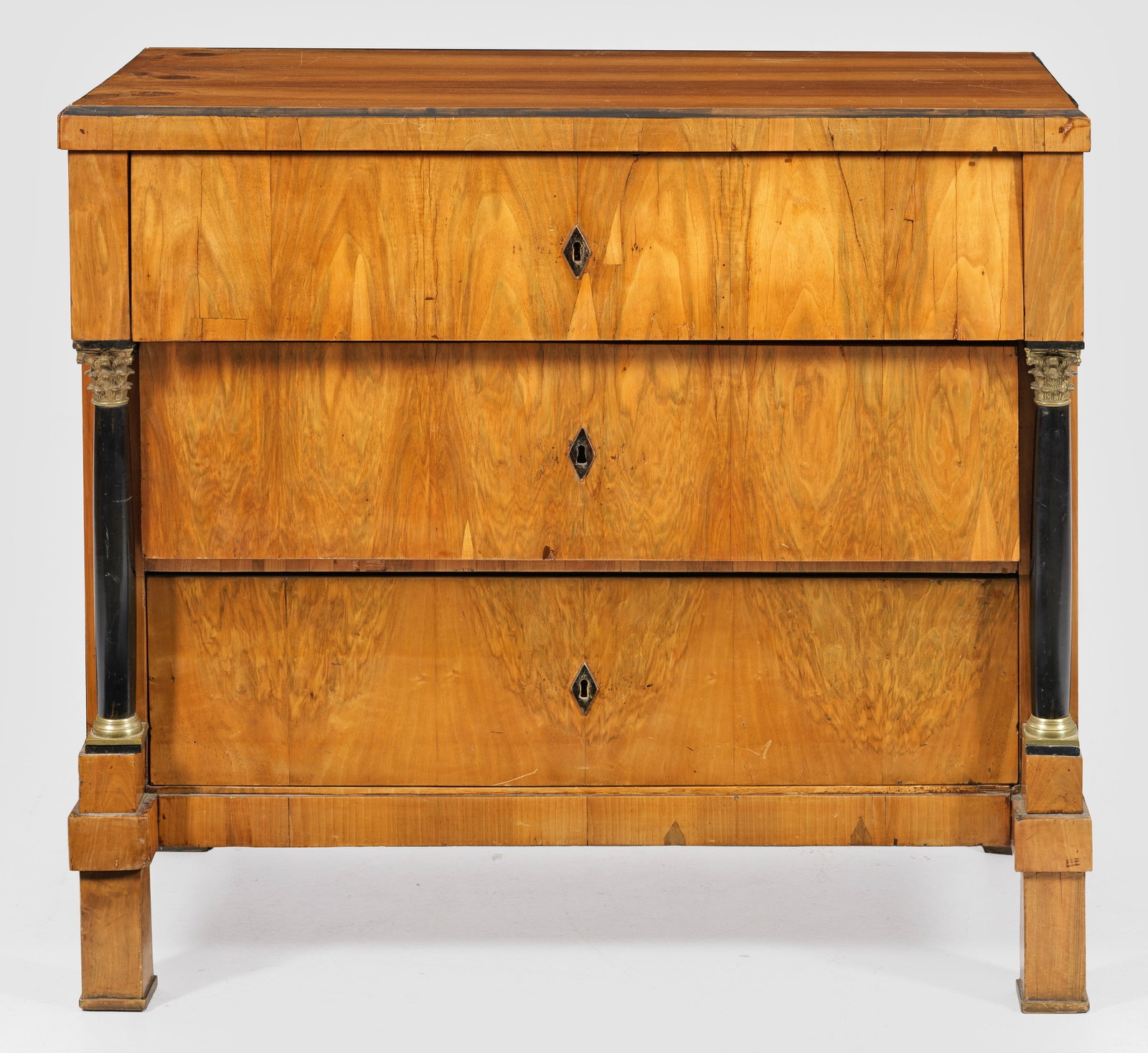 Große Biedermeier-Schreibkommode: Nussbaum, furniert und teilw. ebonisiert. Gerader, querrechteckig angelegter Korpus, flankiert von eingestellten Vollsäulen mit korinthischen Kapitellen auf gekanteten Füßen. In der gegliederten Fr