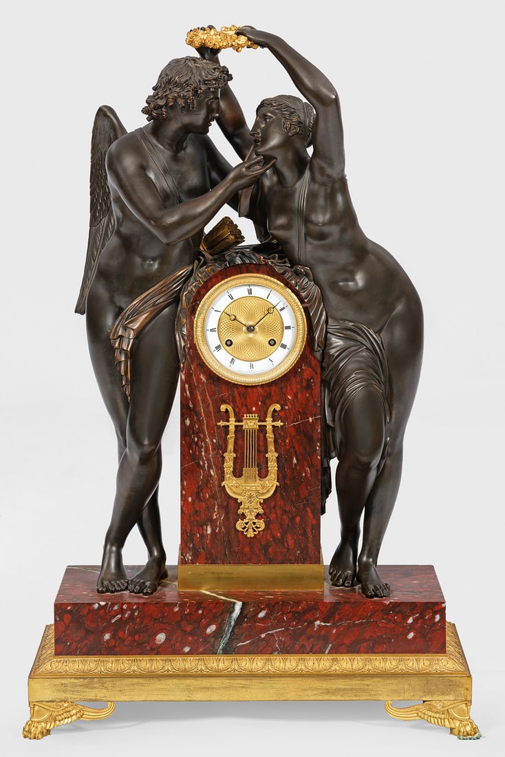 Große Empire-Figurenpendule "Amor und Psyche": nach einem Entwurf von Claude Michallon Bronze, dunkel patiniert und teilw. vergoldet sowie bordeauxroter, grau-weiß gemaserter Marmor. Vollplastische Darstellung von Amor und Psyche mit Rosenkranz, 