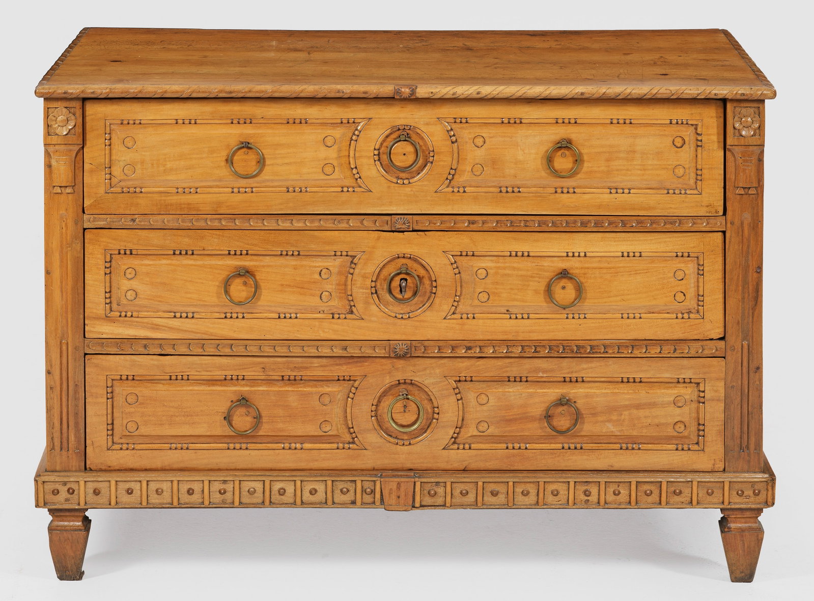 Große Louis XVI-Kommode: aus dem Inventar von Schloss Salem Kirschbaum, teilw. reliefplastisch geschnitzt. Gerader, querrechteckig angelegter Korpus auf profiliertem Zargensockel und gekanteten Balusterfüßen. In der geglied