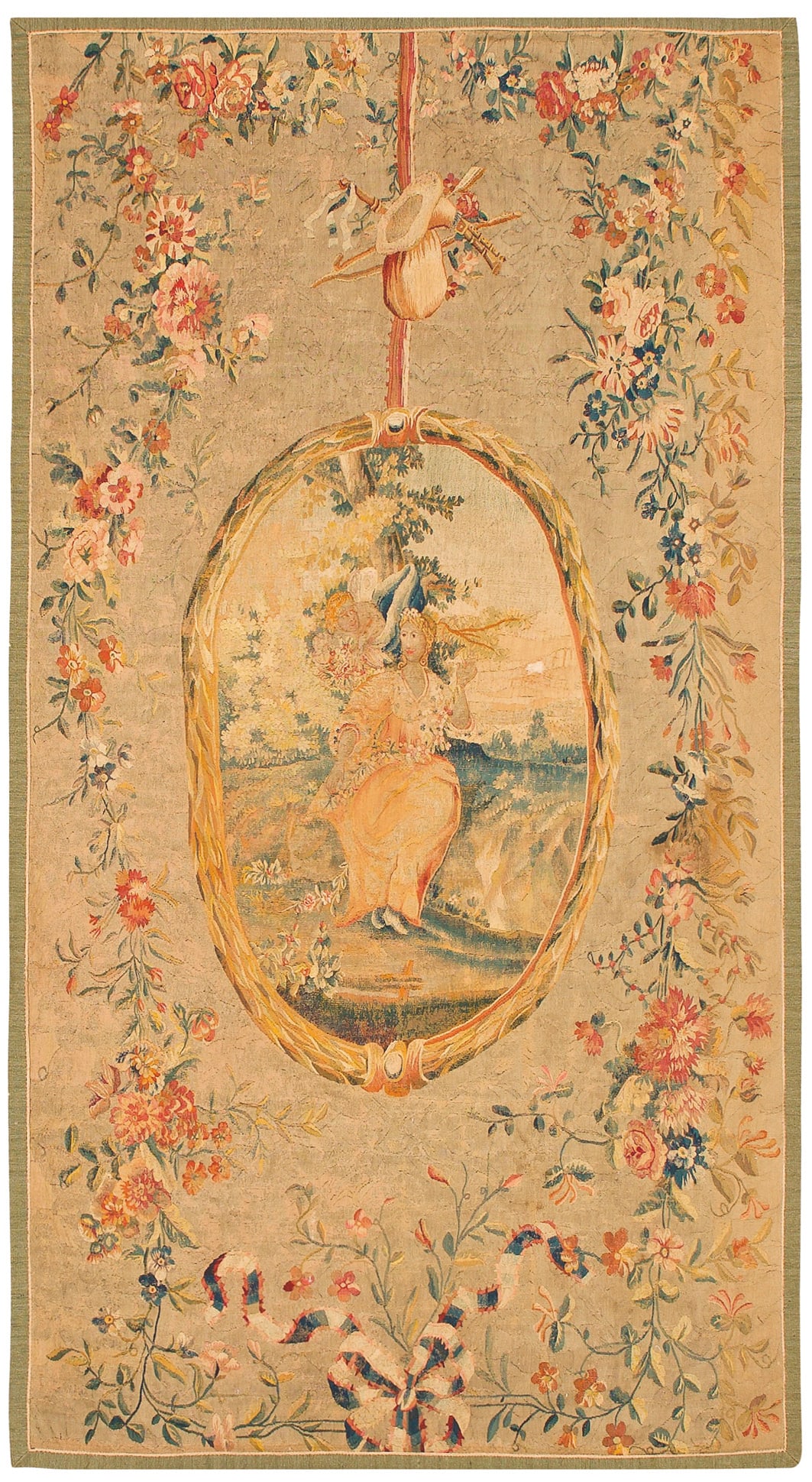 Höfische Louis XVI-Tapisserie: Wolle in unterschiedlichen Creme-, Rosé-, Grün- und Blautönen, flach gewebt. Auf cremefarbenem Fond hochovales, schleifenbekröntes und von Lorbeerblatt gerahmtes Medaillon. Darin szenisch gestalte
