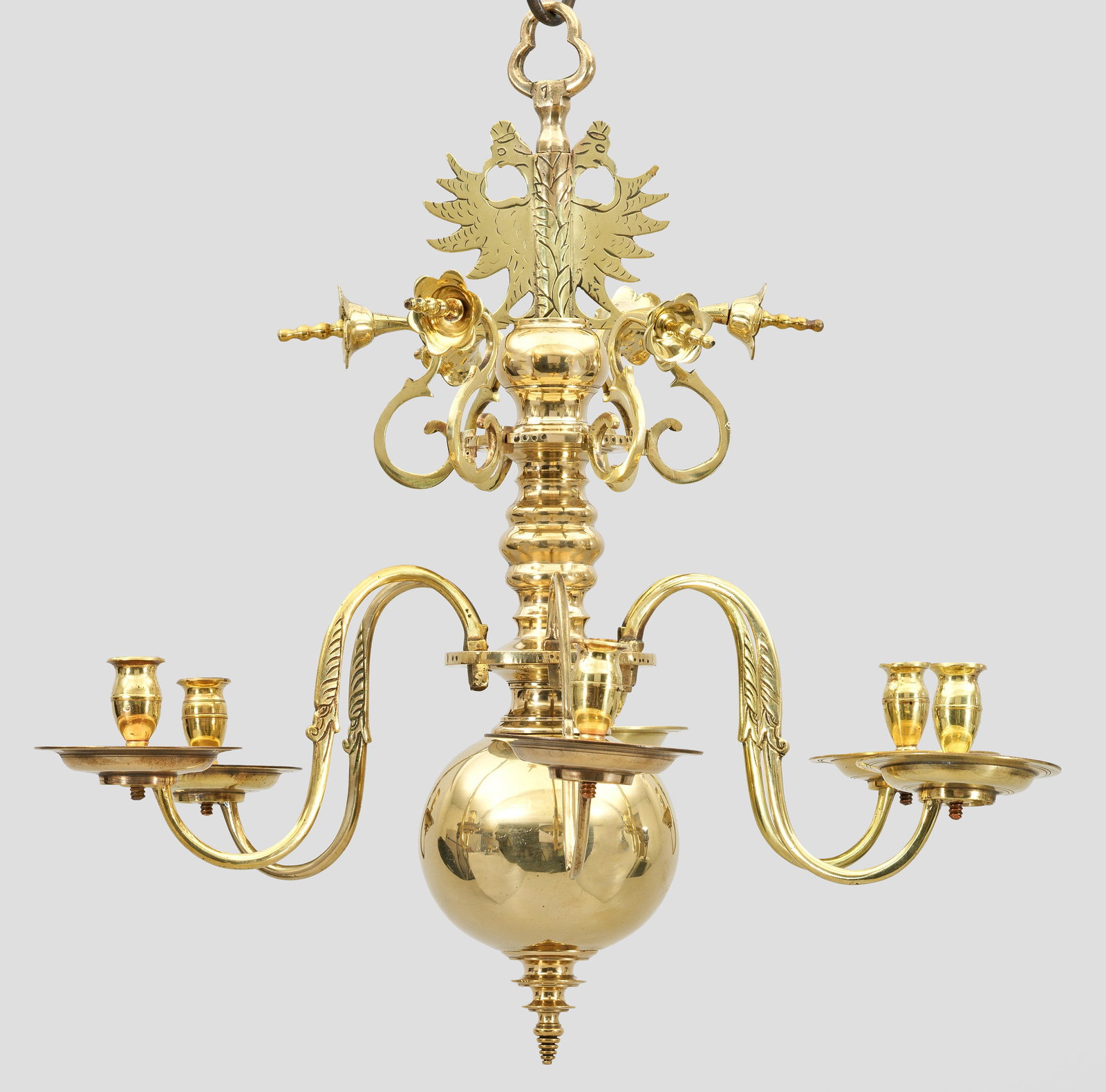 Barock-Deckenkrone: 6-flg.; Messing, poliert. Mehrfach gegliederter Balusterschaft mit kräftigem Kugelabschluss sowie Bekrönung in Form eines Doppeladlers. Davon ausgehend stark geschwungene Leuchterarme mit vasenförm