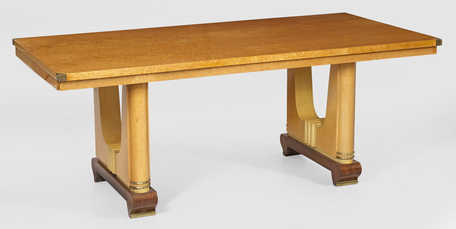 Art Déco-Tisch: Ahorn und Vogelaugenahorn sowie Palisander, furniert. Offen gestaltete Seitenwangen, flankiert von eingestellten Halbsäulen auf niedrigen Volutenfüßen. Rechteckige Deckplatte. An den Kurzseiten aus