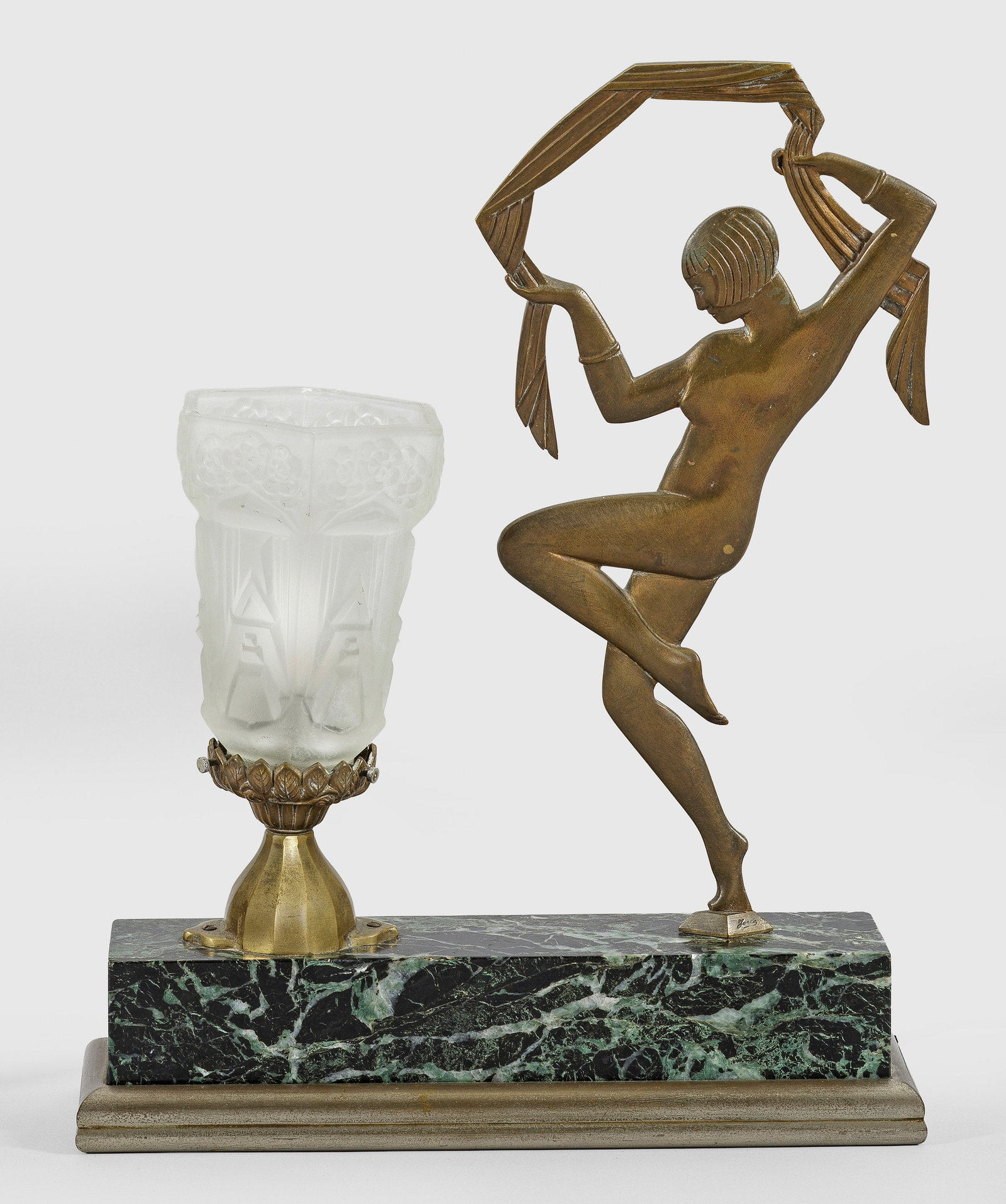Art Déco-Tischlampe: 1-flg.; Bronze, teilw. vernickelt sowie grün gemaserter Marmor und farbloses, satiniertes Glas. Über querrechteckig angelegtem Sockel flach reliefierte Tänzerin sowie kelchförmiger Lampenschirm ü