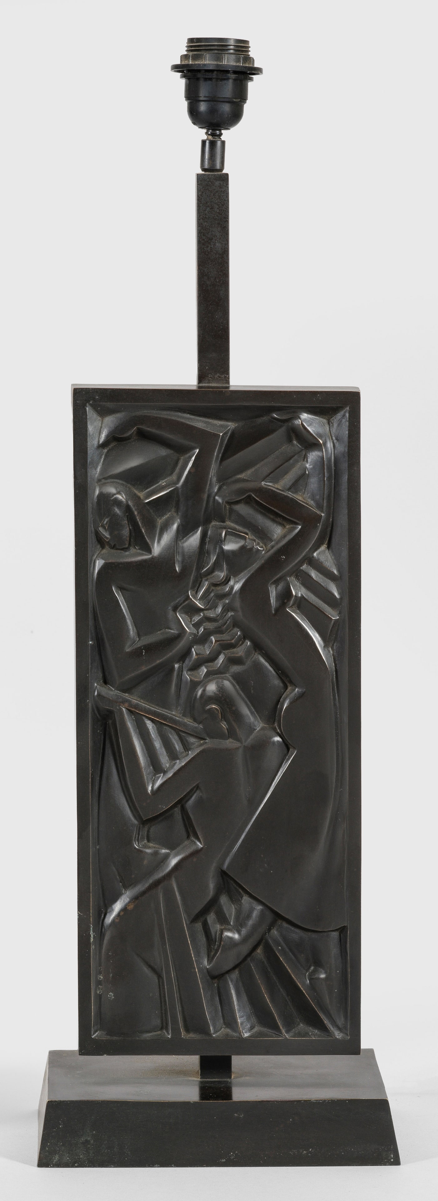 Tischlampe im Art Déco-Stil: nach einem Entwurf von Jan und Joël Martel 1-flg.; Bronze, dunkel patiniert. Über querrechteckigem, sich leicht verjüngendem Sockel hochrechteckiges, figural reliefiertes Paneel nach der berühmten