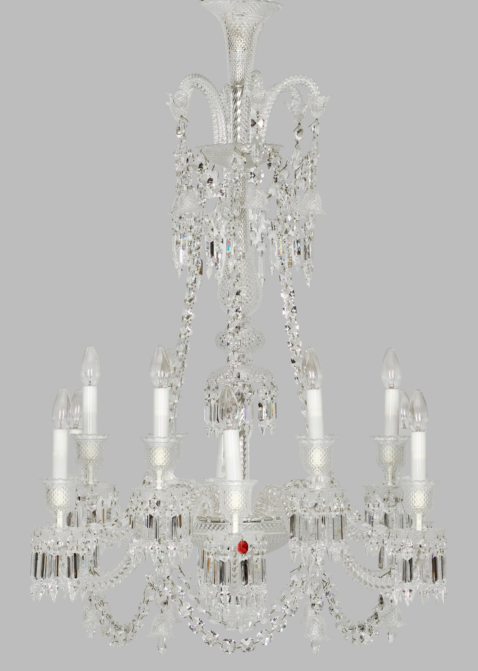 Luxuriöser Deckenlüster "Zénit" von Baccarat: 12-flg.; Farbloses Kristallglas. Mehrfach gegliederter Balusterschaft. Unterhalb davon ausgehend stark geschwungene, in sich gedrehte Leuchterarme als Träger für Leuchtmittel. Tief gemuldete Traufsc