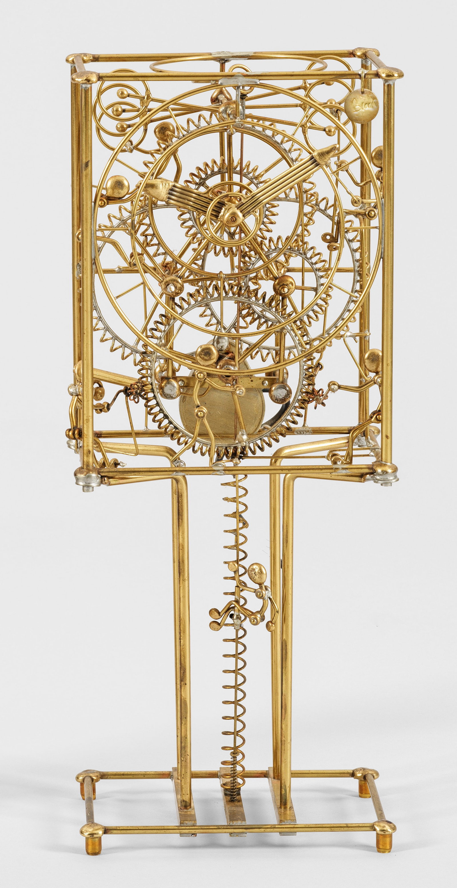 "Seven Man Clock" von Gordon Bradt: Messing, gelötet. Skelettartig angelegter Korpus aus schmalen Rundstäben mit gewickeltem Getriebe und stilisierten, beweglichen Figuren, den Antrieb begleitend. Herstellerplakette. Stromantrieb. H. 