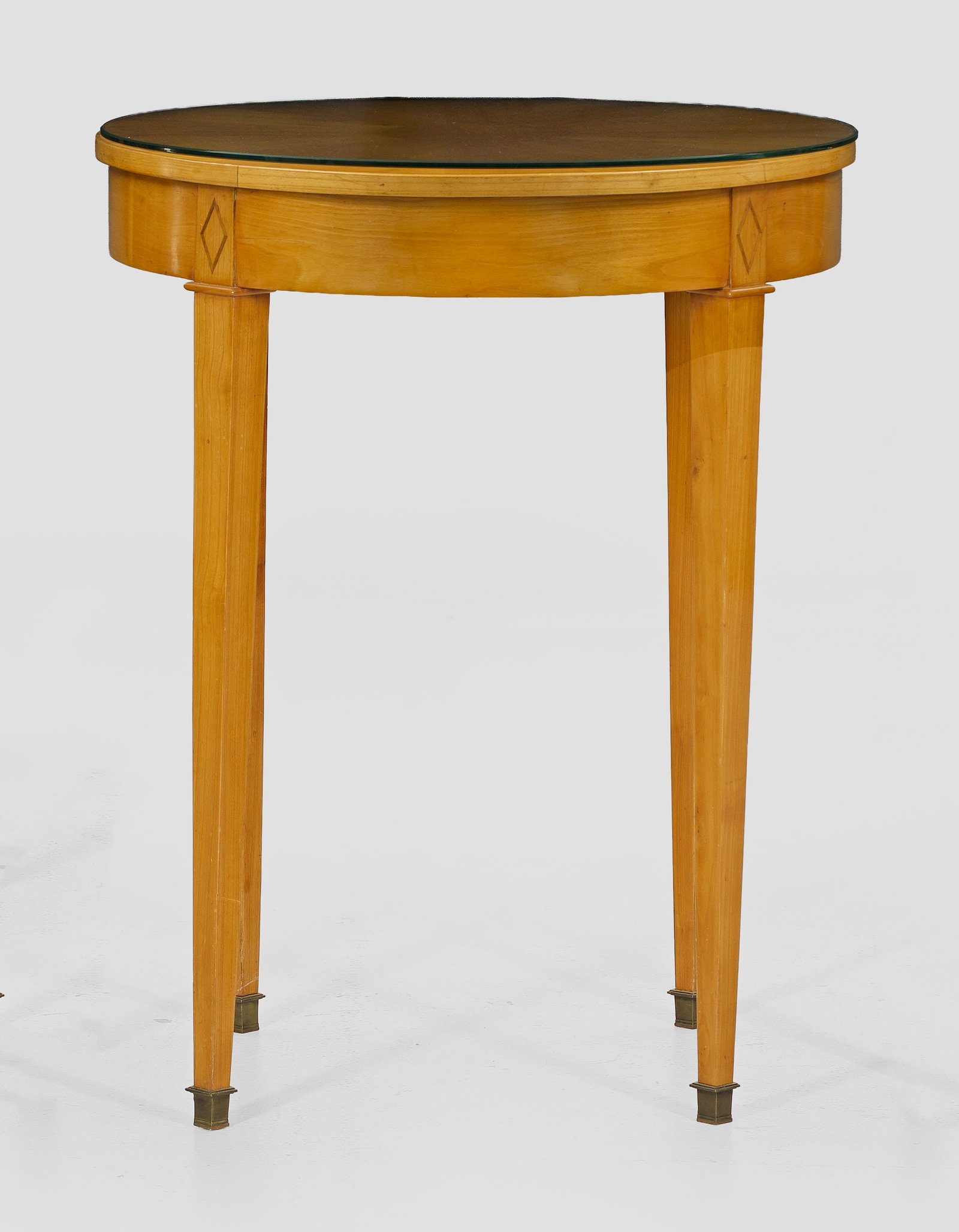 Beistelltisch im Biedermeierstil: Kirschbaum, furniert. Bombierte Zarge auf hohen, konischen Vierkantbeinen mit Messingkappen als Träger für runde Deckplatte. H. 74 cm. 58,5 cm. A South German cherrywood veneered Biedermeier style s