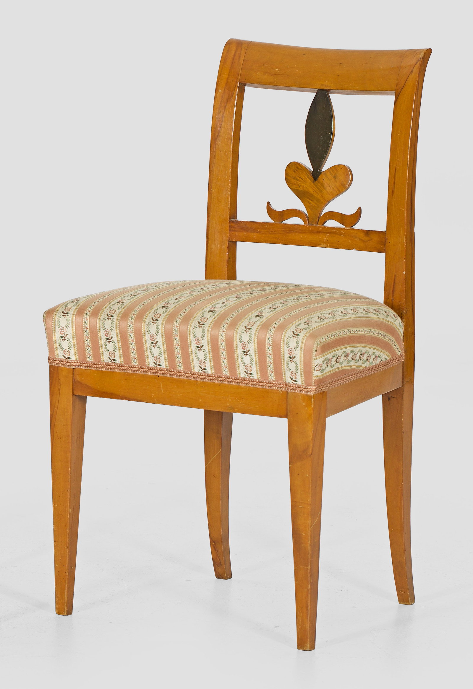 Biedermeier-Stuhl: Obstholz, teilw. ebonisiert. Trapezförmige Zarge auf konischen Vierkantbeinen. Offen gestaltete Rückenlehnenrahmung. Sitzfläche gepolstert und bezogen. H. 49 cm. A South German fruitwood Biedermeie