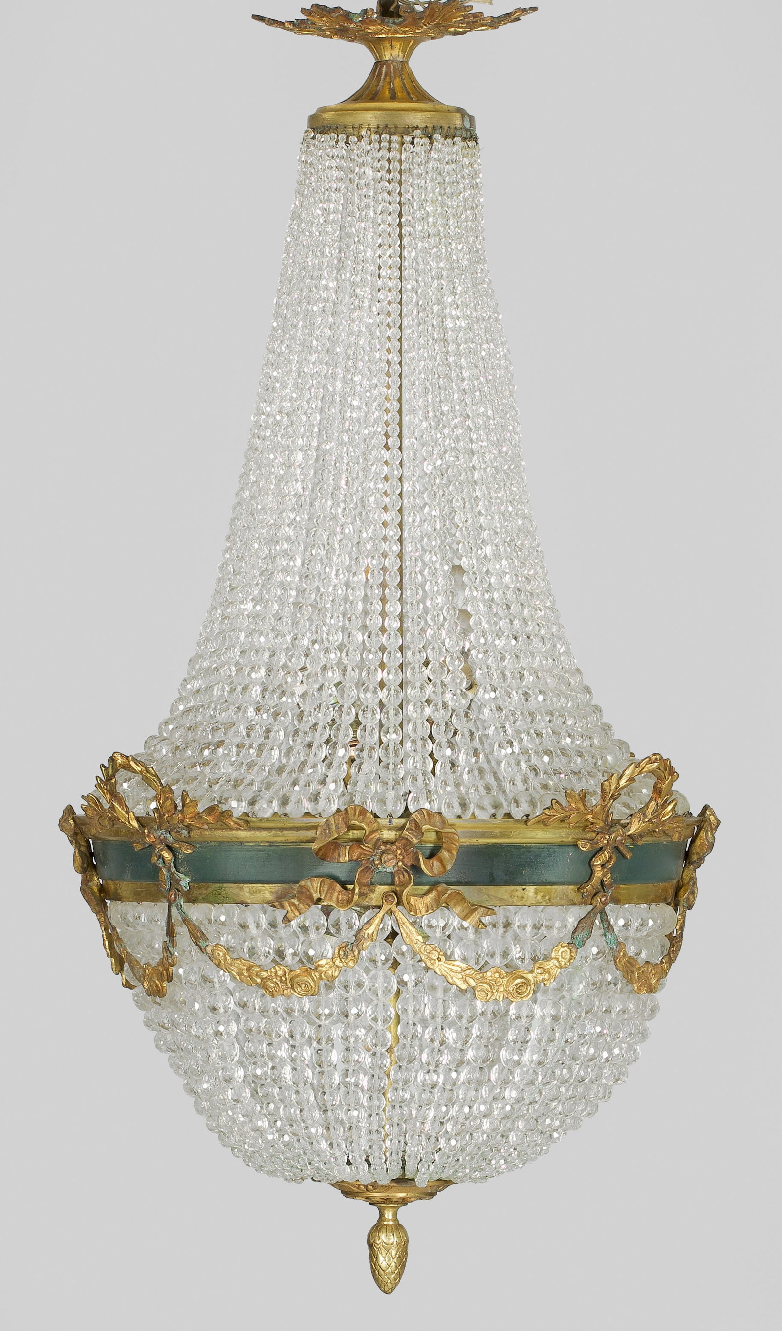Deckenlüster im Empire-Stil: Bronze, teilw. lackiert und farbloses Glas. Balusterförmiger Korpus aus Prismenschnüren im Verkauf. Dazwischen breiter, profilierter Reif mit applizierten Lorbeerkränzen und Schleifenmotiven, durch