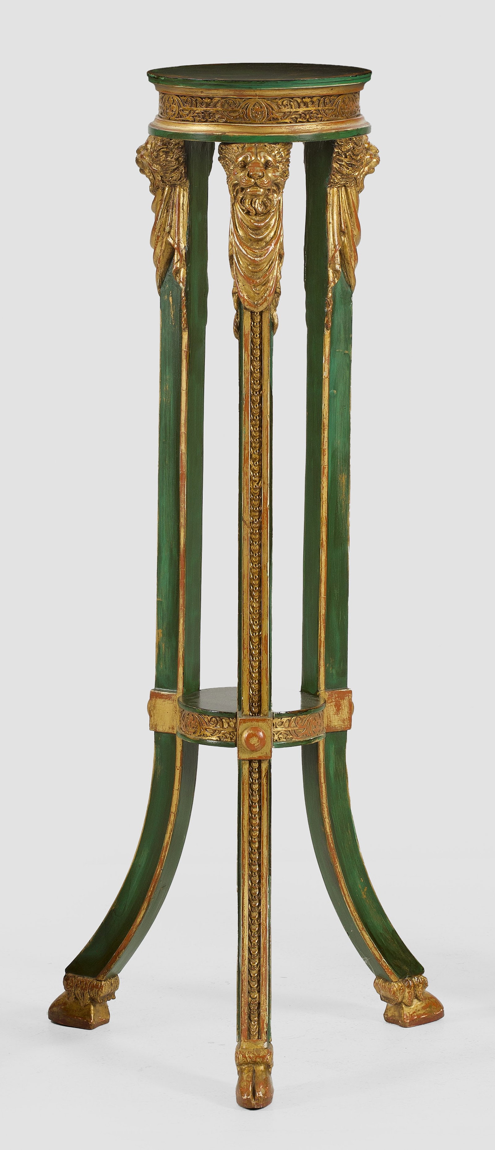 Gueridon im Louis XVI-Stil: Holz, grün gefasst und teilw. vergoldet. Gekantete, ausgestellte Streben mit Schuppenfries sowie plastischen Löwenmaskarons mit Draperiewerk als Träger für runde, profilierte Deckplatte sowie korr