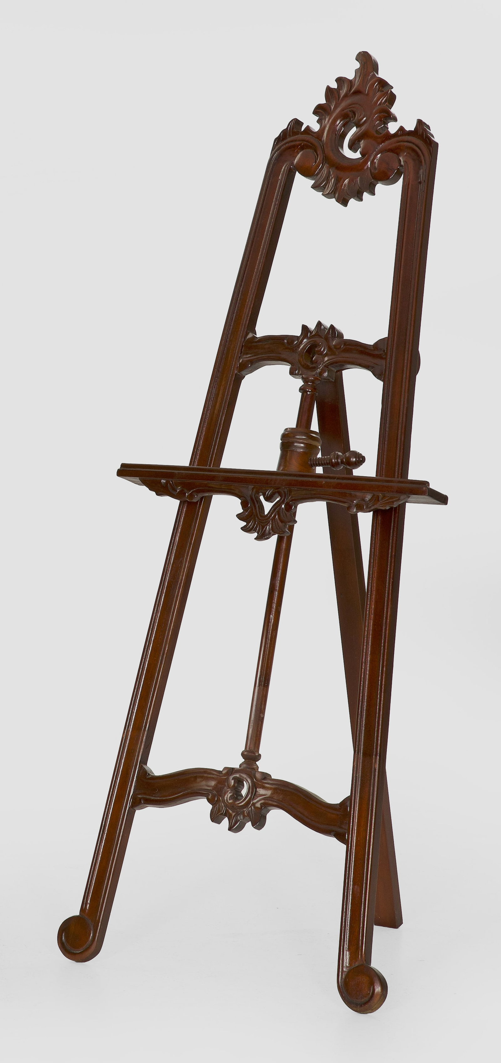 Staffelei im Rokoko-Stil: Mahagoni. Gestell aus flachen, schräggestellten Streben mit asymmetrisch angelegter Rocaillebekrönung. Höhenverstellbare Abstellfläche. H. 144 cm. A French mahogany Rococo style easel. Frankreich.