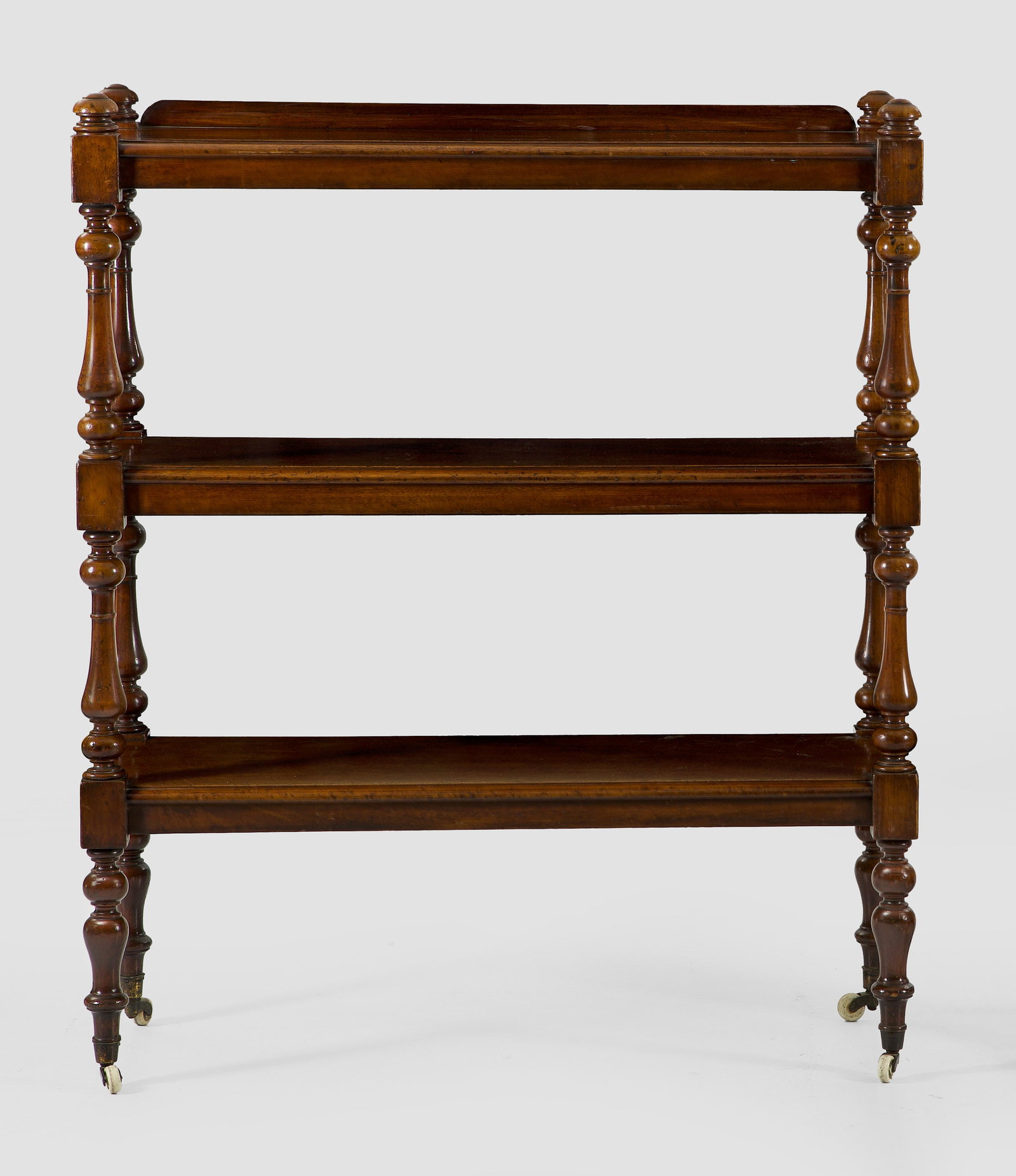 Viktorianisches Regal: Mahagoni, massiv. Offen gestalteter Korpus auf mehrfach gegliederten Balusterstäben und breiten, profilierten Ablageflächen auf Porzellanrollen. H. 127 cm. 107 cm x 38,5 cm. An English Victorian mah