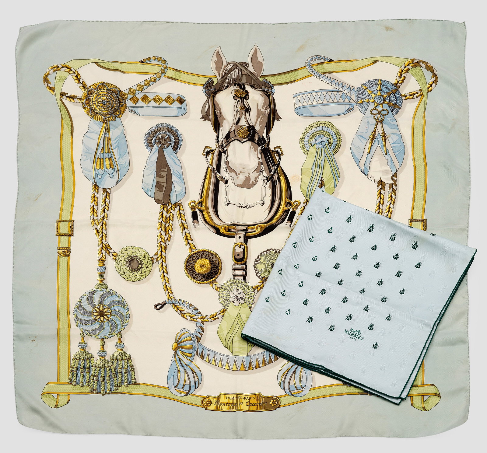 Zwei Seidentücher von HERMÈS: "Frontaux et Cocardes" bzw. "Petite Abeille" sog. "le Carré". Muster aus gestickten, dunkelgrünen Bienen in hellgrünem Fond bzw. polychrome Darstellung eines Pferdes umgeben von dekorativer Staffag