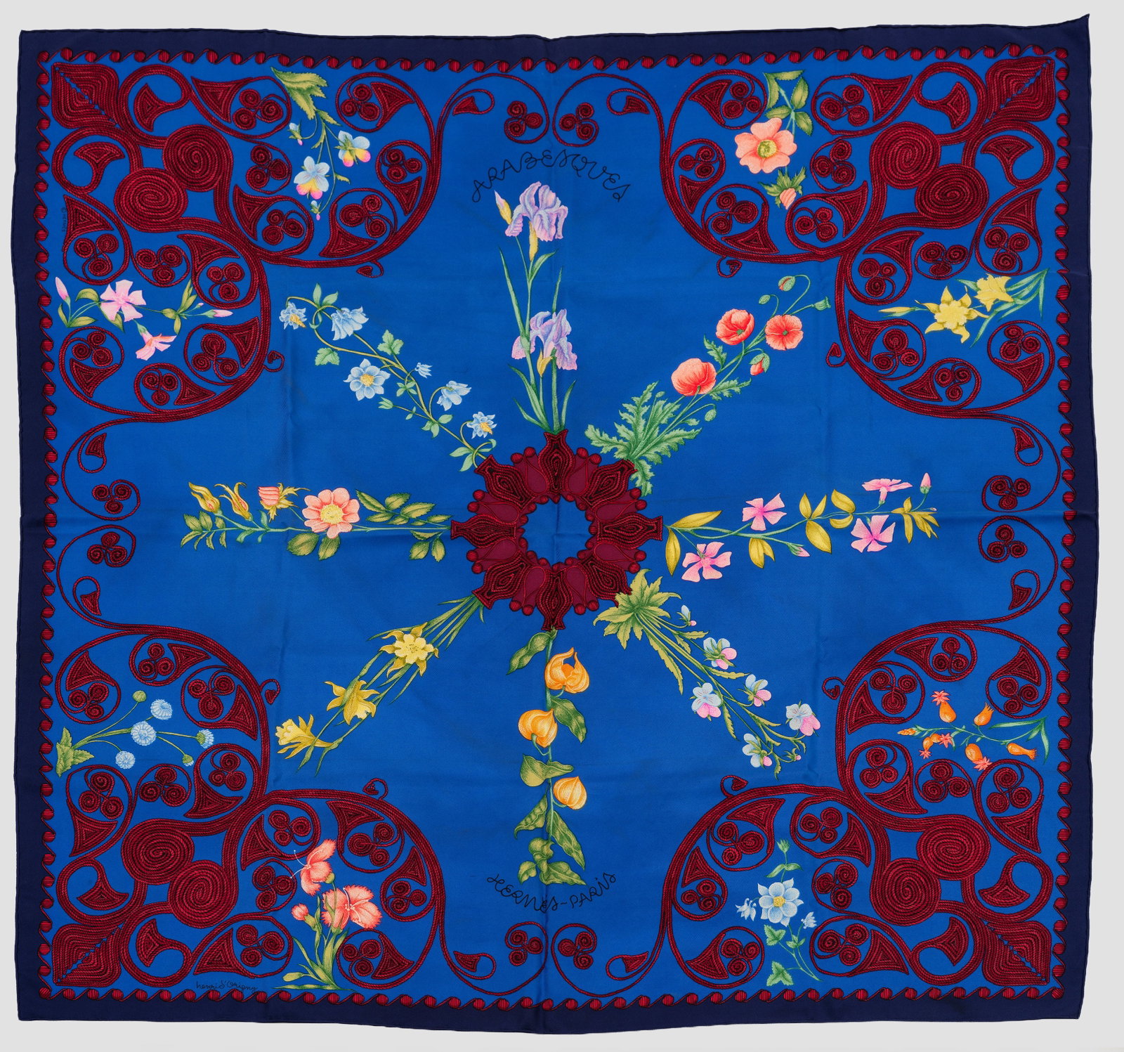 Seidentuch "Arabesques" von HERMÈS: mit Box. Sog. "le Carré". Quadratisches Tuch. Marineblauer Grund mit tiefblauer Kontur. Aus Vasenrosette farbenprächtig empor sprießende polychrome Blütengewächse mit breiter Ornamentbordüre in 