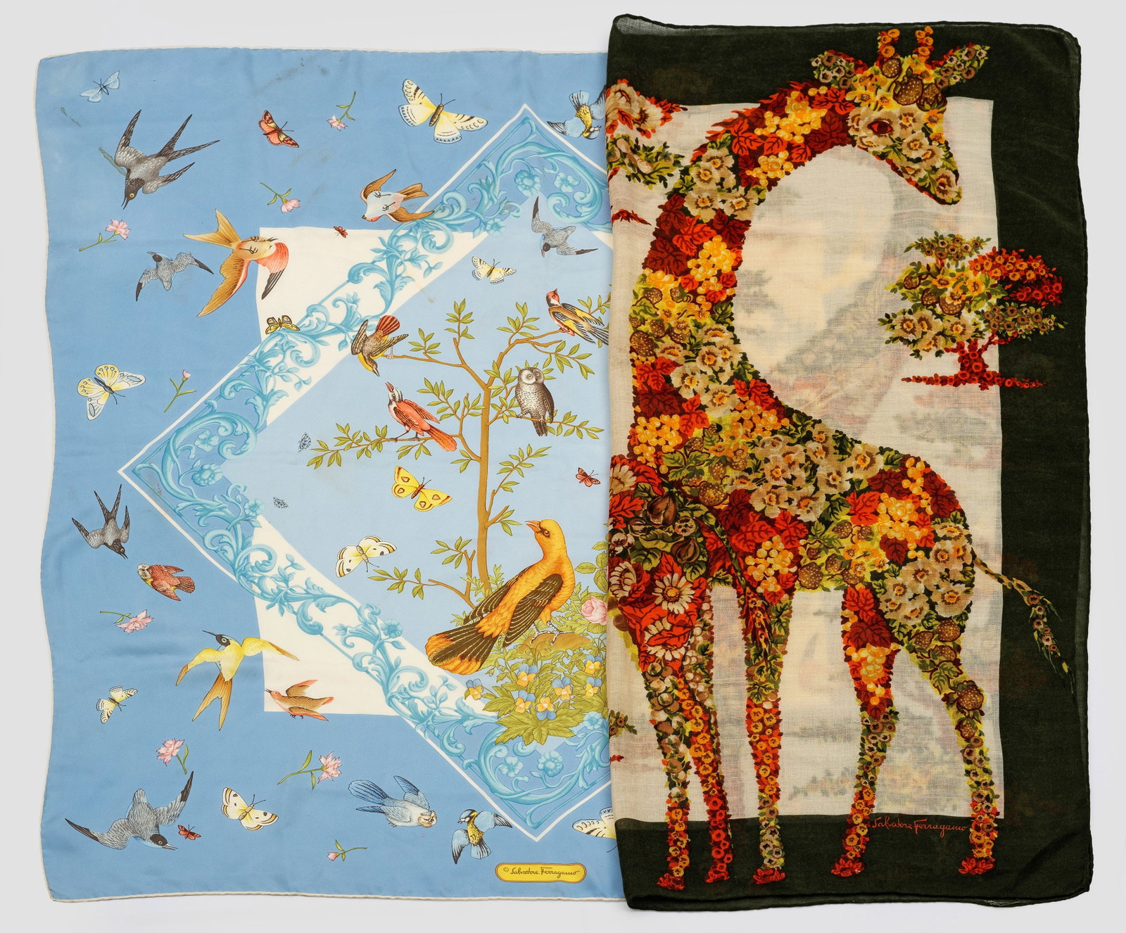 Zwei Vintage-Tücher von Salvatore Ferragamo: Seide und Wolle. Quadratische Tücher mit polychromem Dekor aus Vögeln vor himmelblauem Grund bzw. aus Blumen zusammengesetzten Giraffen. Herstellerzeichen. Minim. Gebrauchsspuren. Ca. 85 cm x 85 cm.