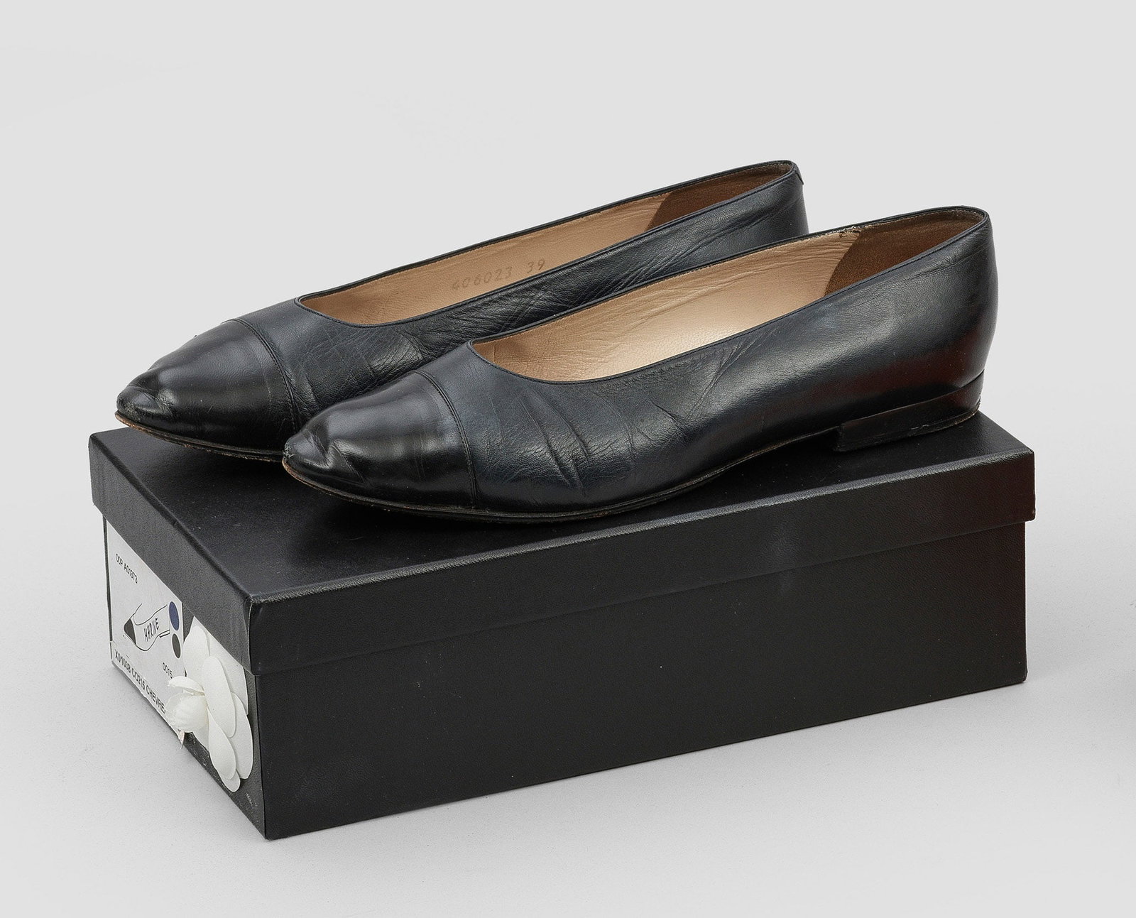 Paar klassische Ballerinas von CHANEL: Dunkelblaues Leder. Klassisch geschnittener Damenschuh mit abgesetzter Spitze. Herstellerzeichen. Gr. 39. Staubbeutel sowie Karton mit Chanel Kamelie. Getragen. A pair of classic Vintage ballerinas by