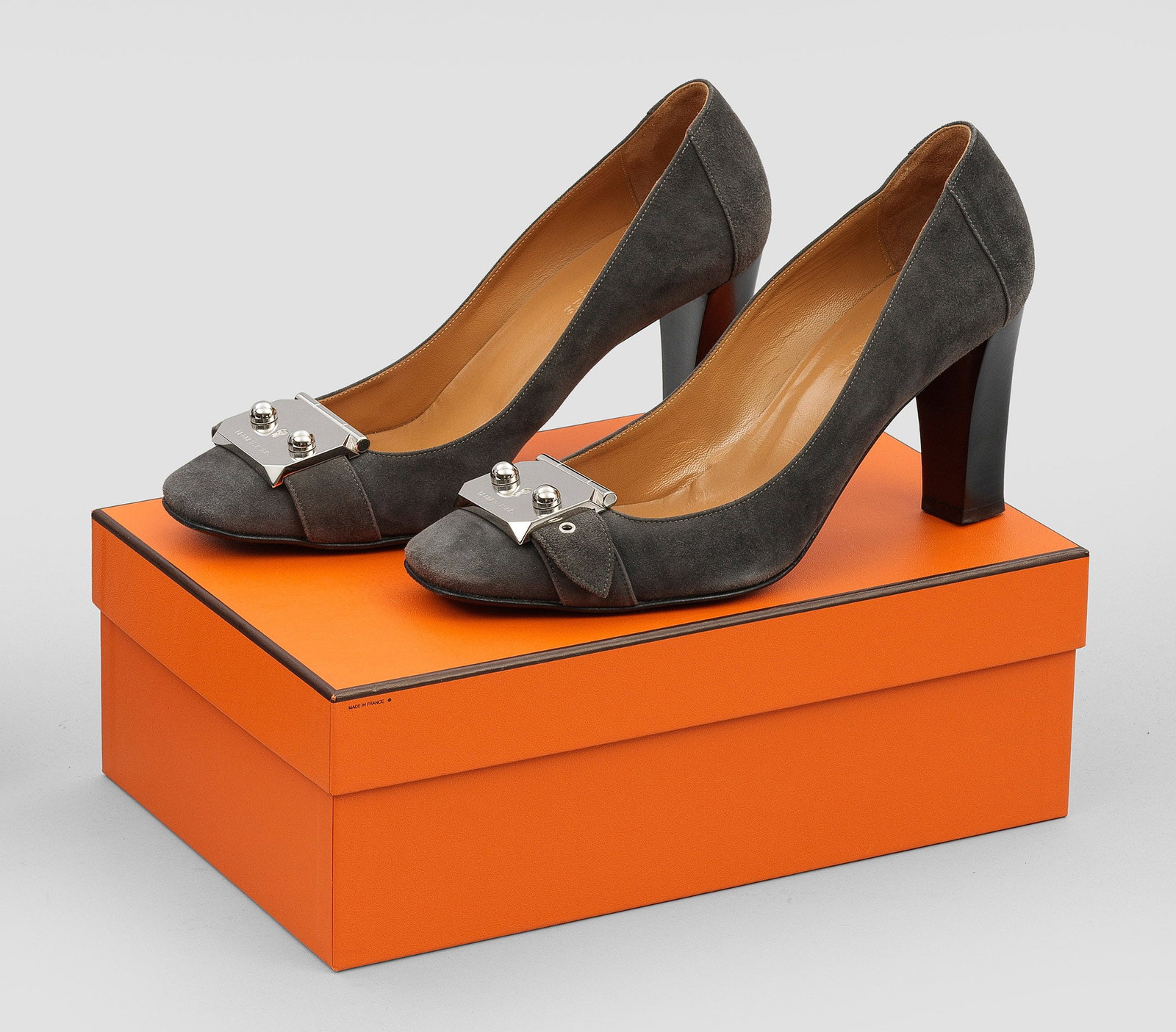 Paar Pumps von HERMÈS: "Remake 85". Graues Velourleder und palladiumfarbene Hardware. Klassischer Pump mit großem Schlosselement. Gr. 38. Getragen. Original Box und Staubbeutel. A pair of pre-owned grey leather pumps by HE