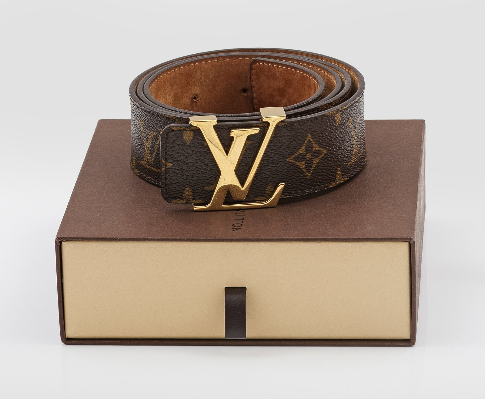 Gürtel von LOUIS VUITTON: Monogram-Canvas und braunes Leder. Vergoldete LV-Messingschnalle. Modell-Nr. 9608. Länge 100/40. Löcher erg.; Staubbeutel und Original Box. A Louis Vuitton belt. Holes added. Signs of age. Box and d